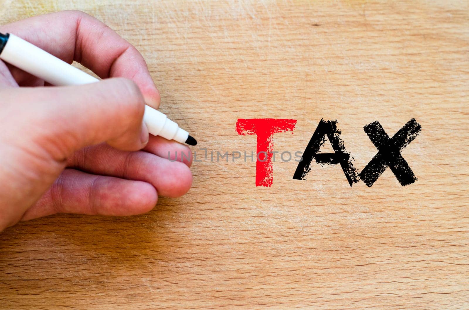 Human hand over wooden background and tax text concept