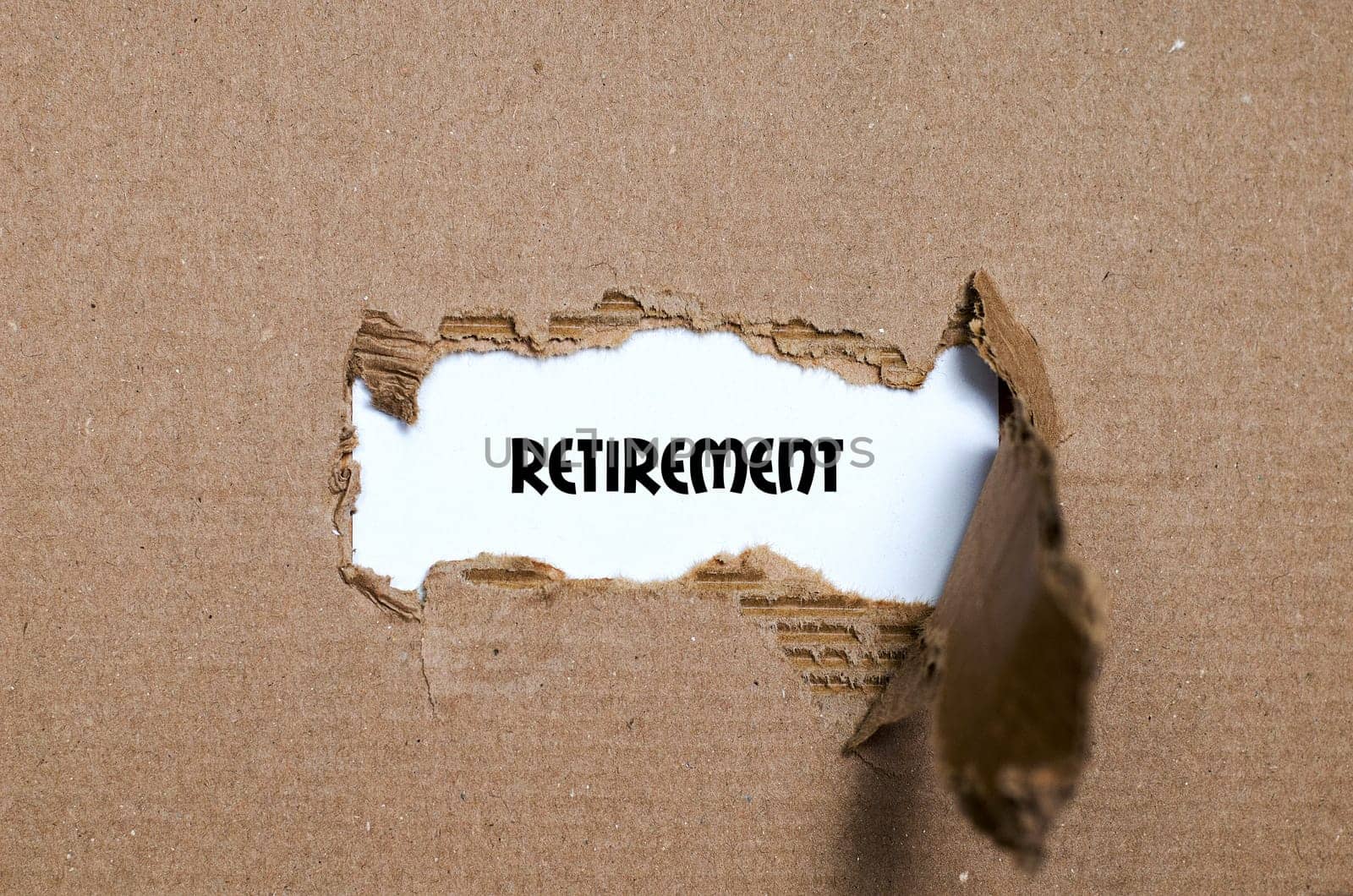 The word retirement appearing behind torn paper