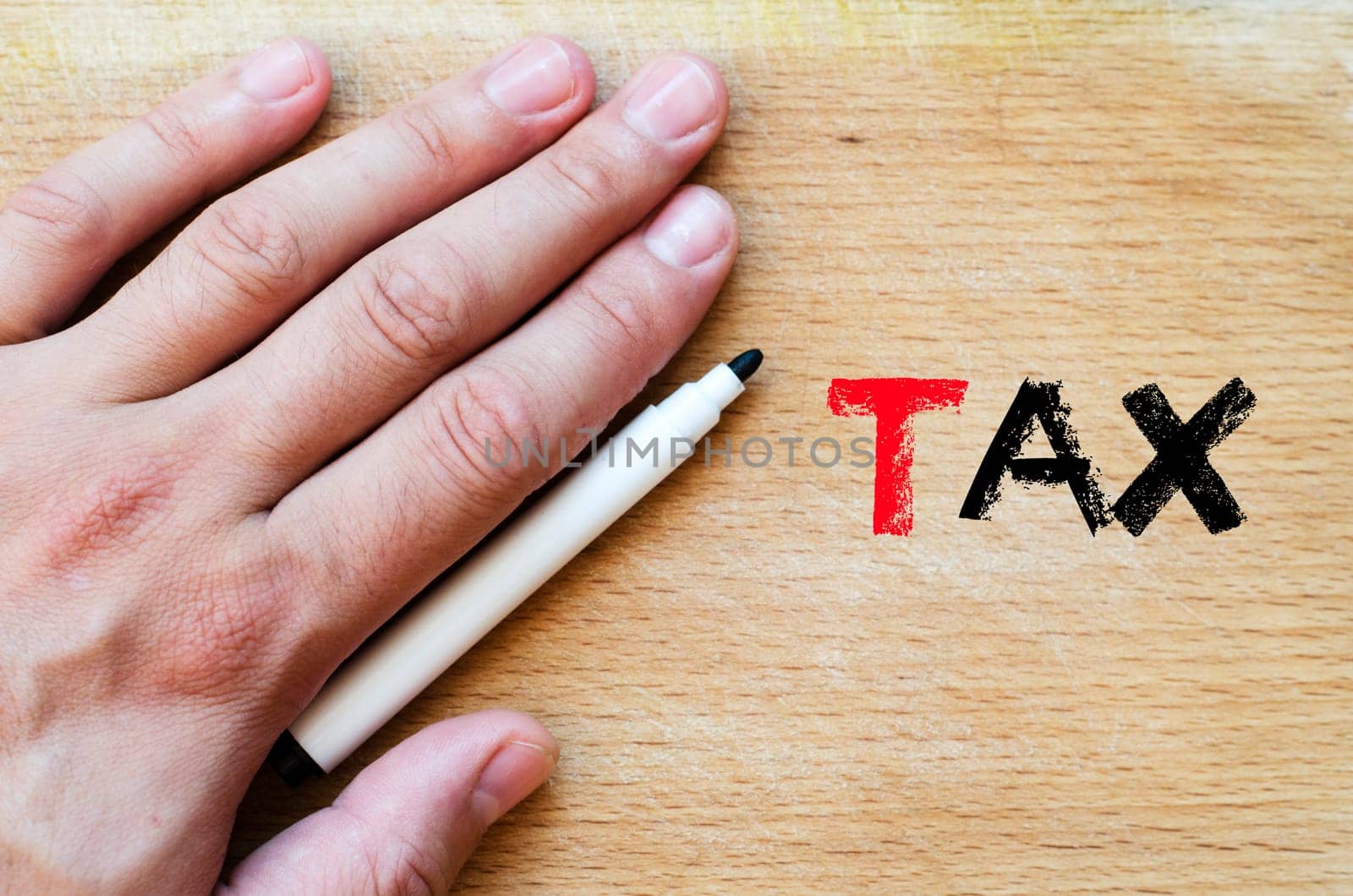 Human hand over wooden background and tax text concept