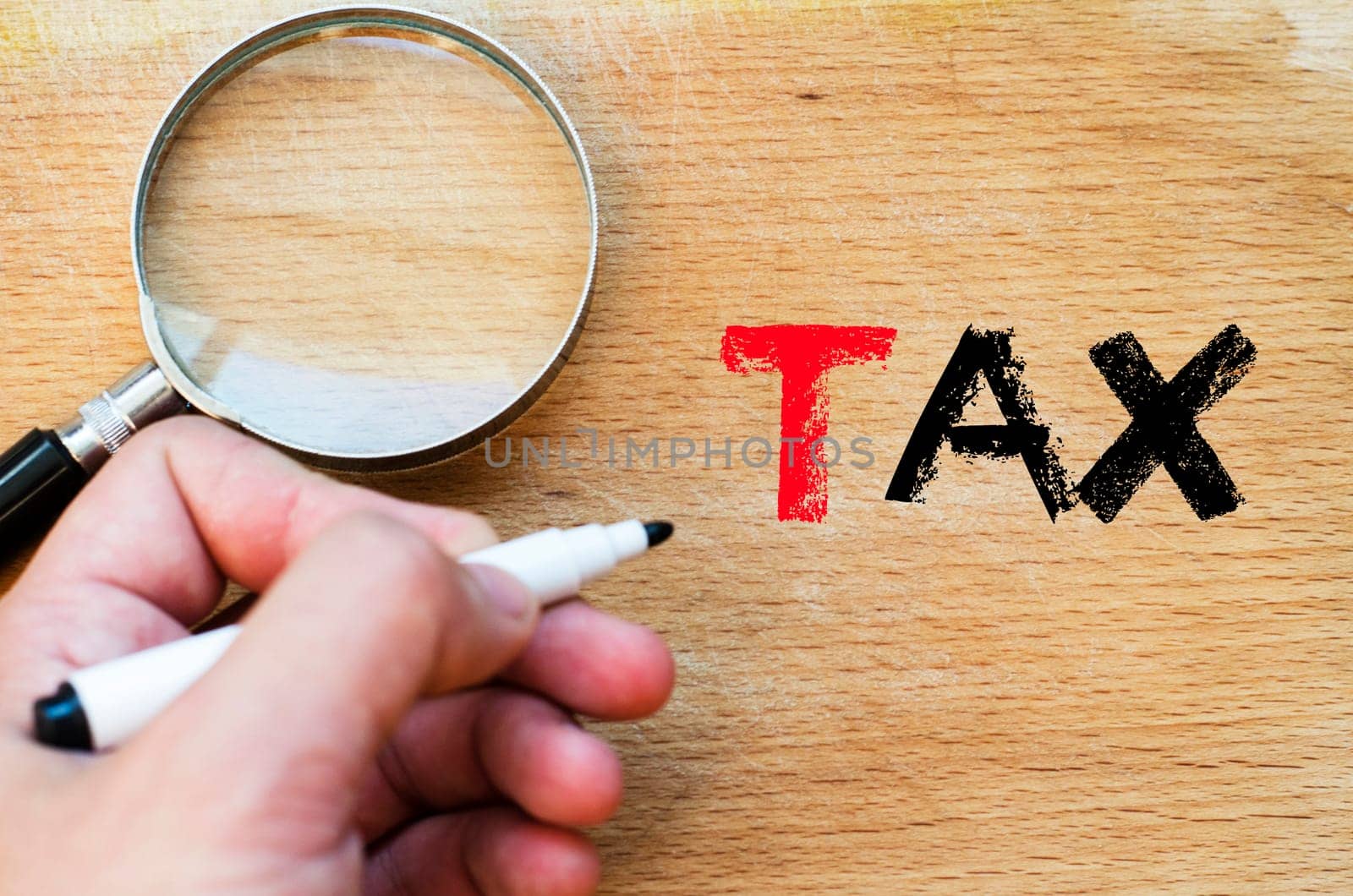 Human hand over wooden background and tax text concept