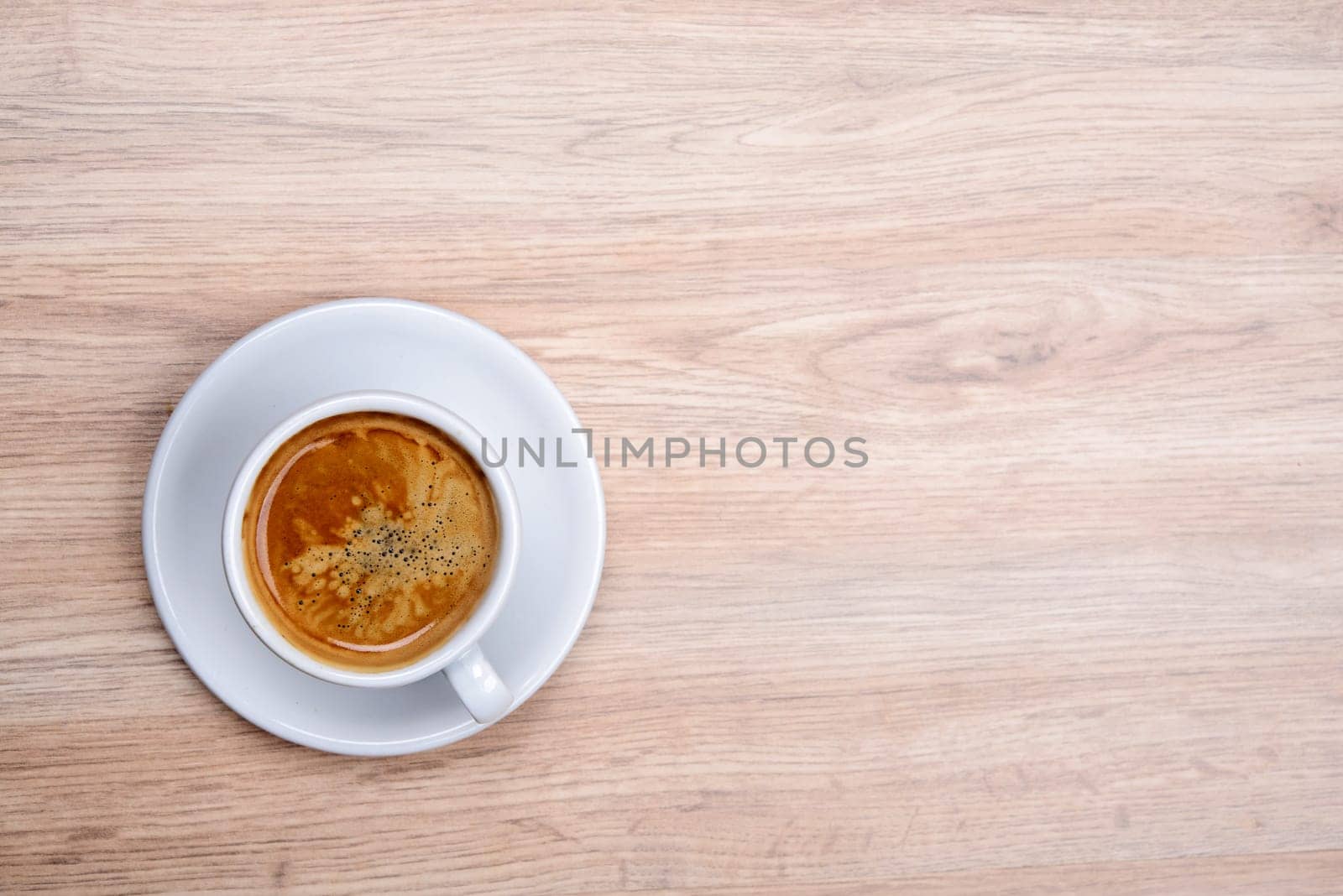 cup of coffee on wooden table from above