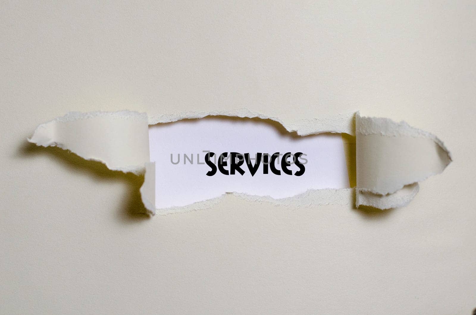 The word services appearing behind torn paper