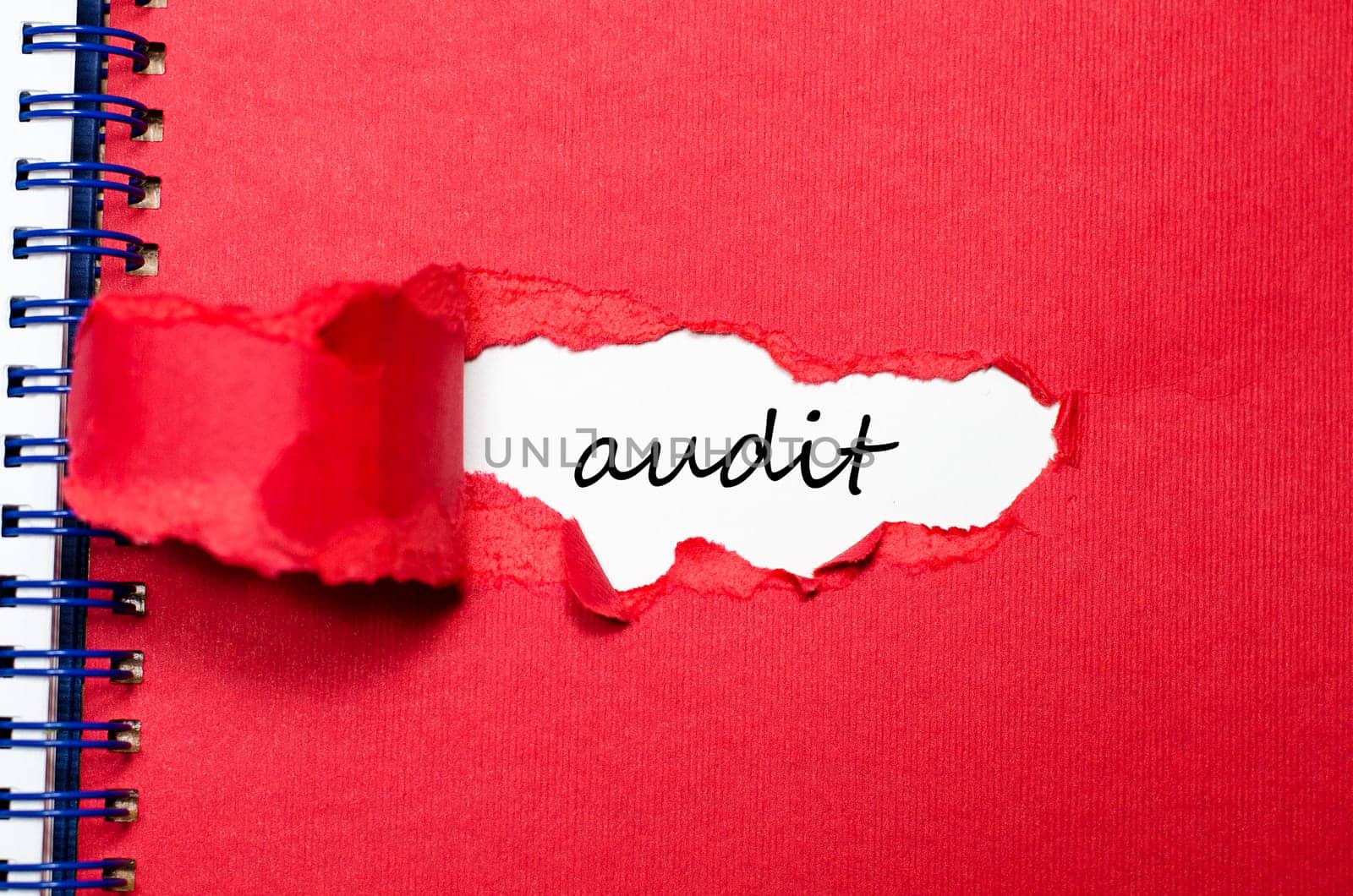 The word audit appearing behind torn paper