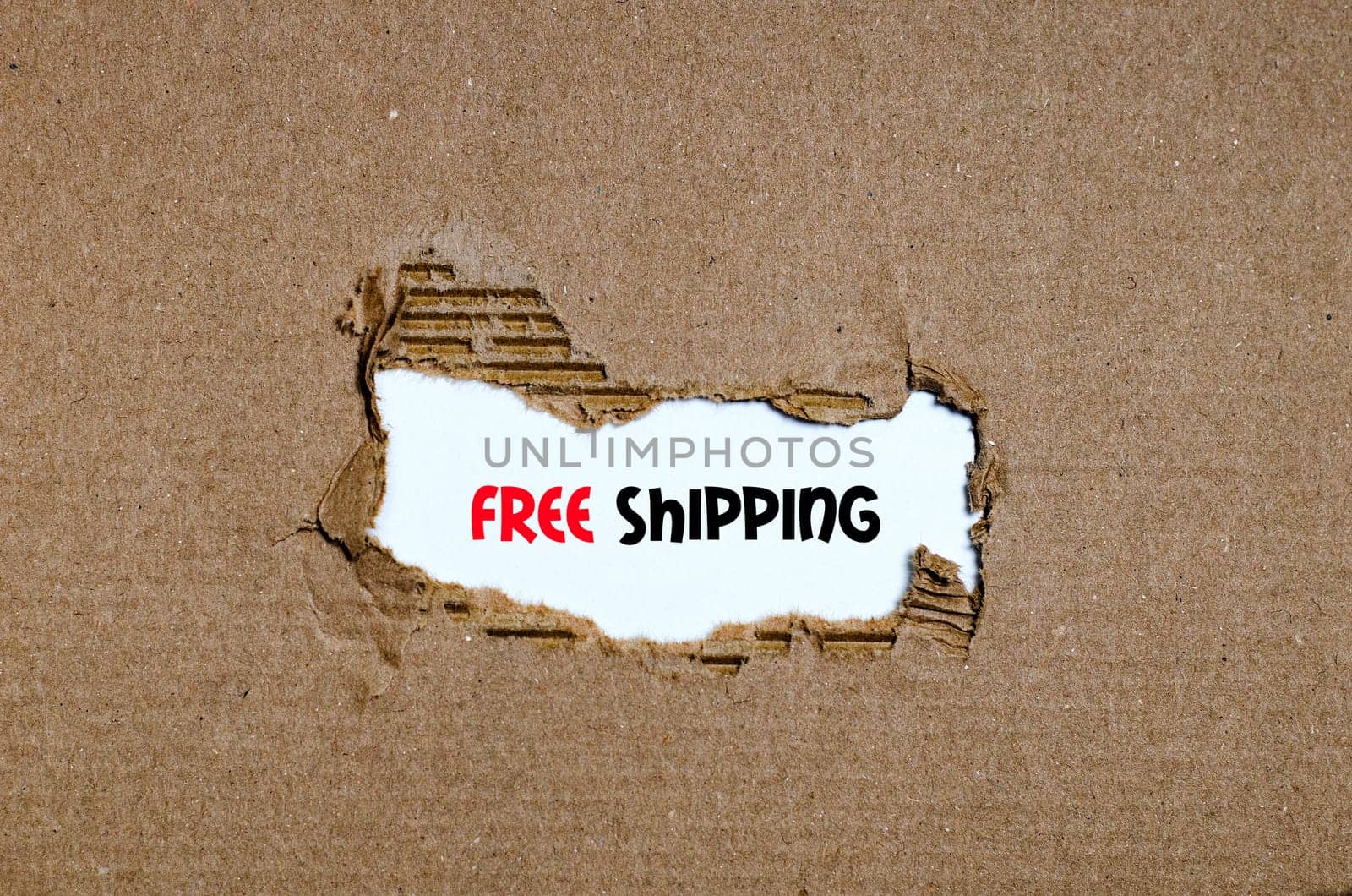 The word free shipping appearing behind torn paper