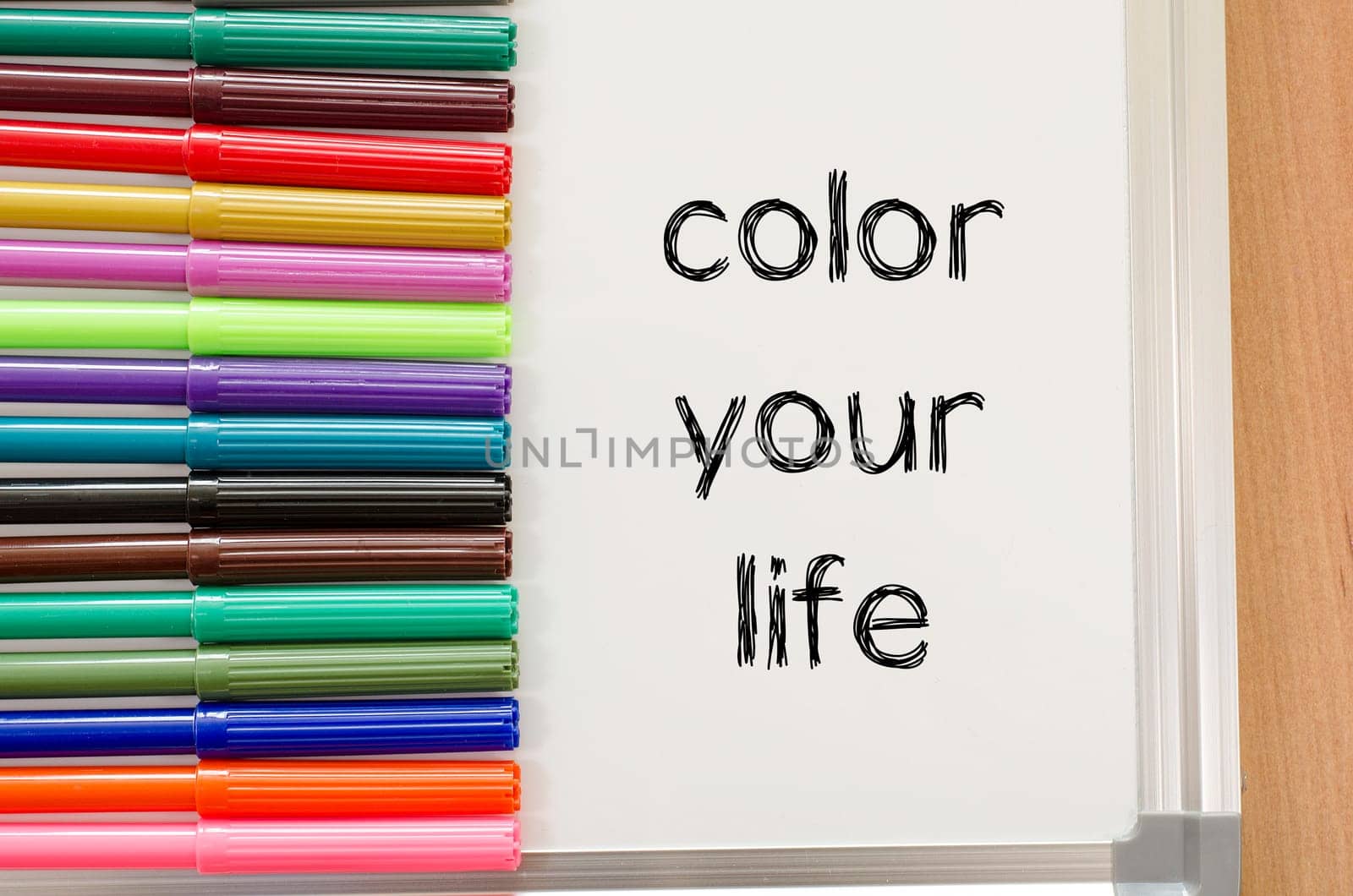 Felt-tip pen and whiteboard on a wooden background and color your life text concept