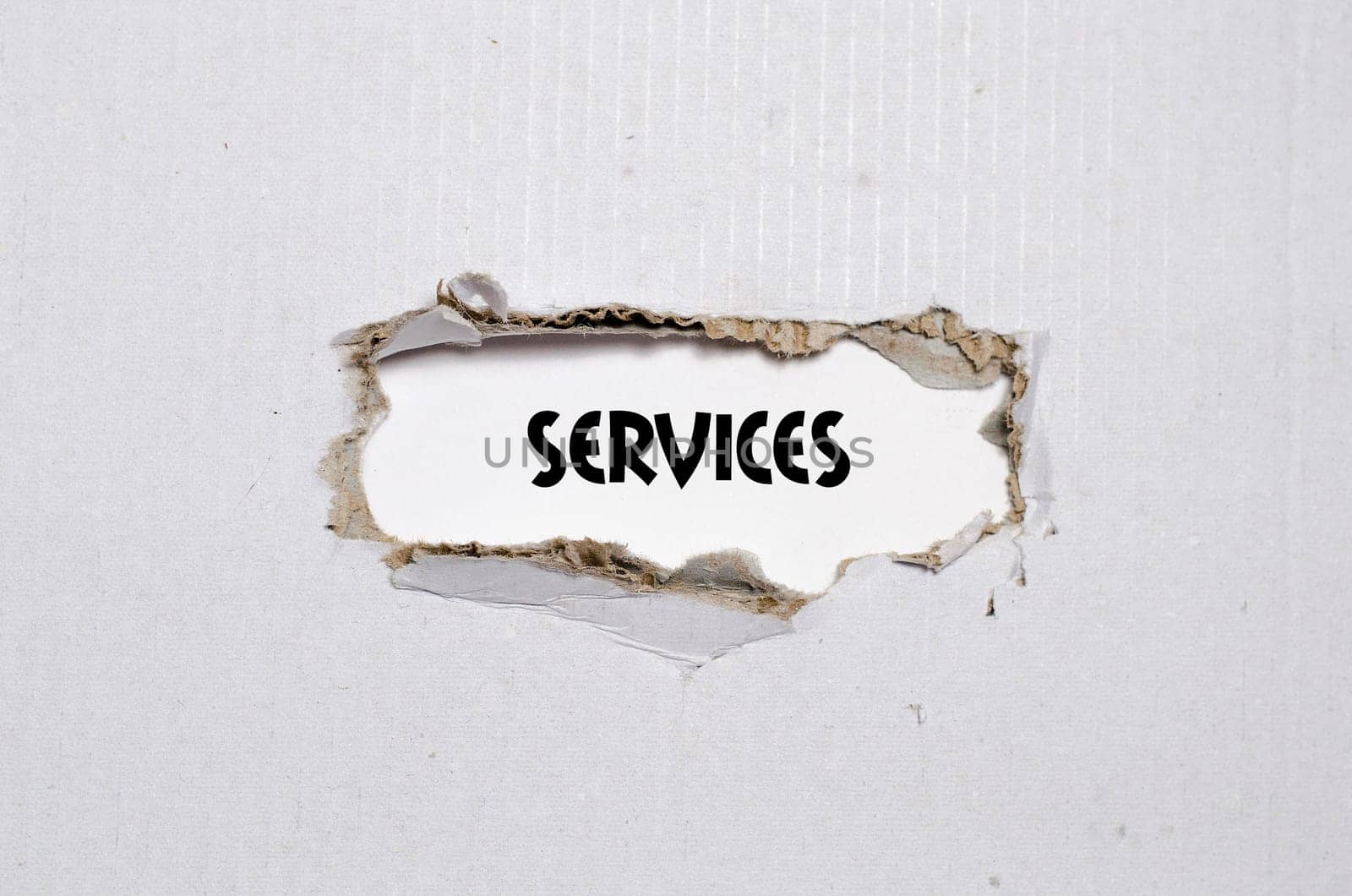 The word services appearing behind torn paper