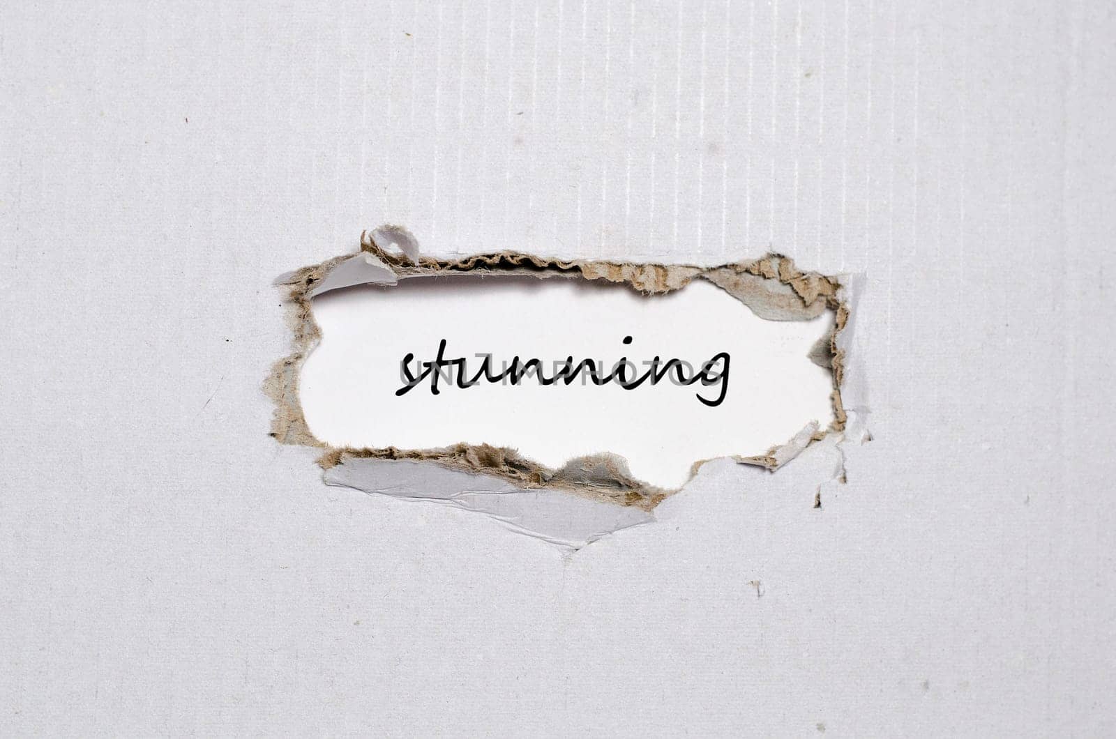 The word stunning appearing behind torn paper