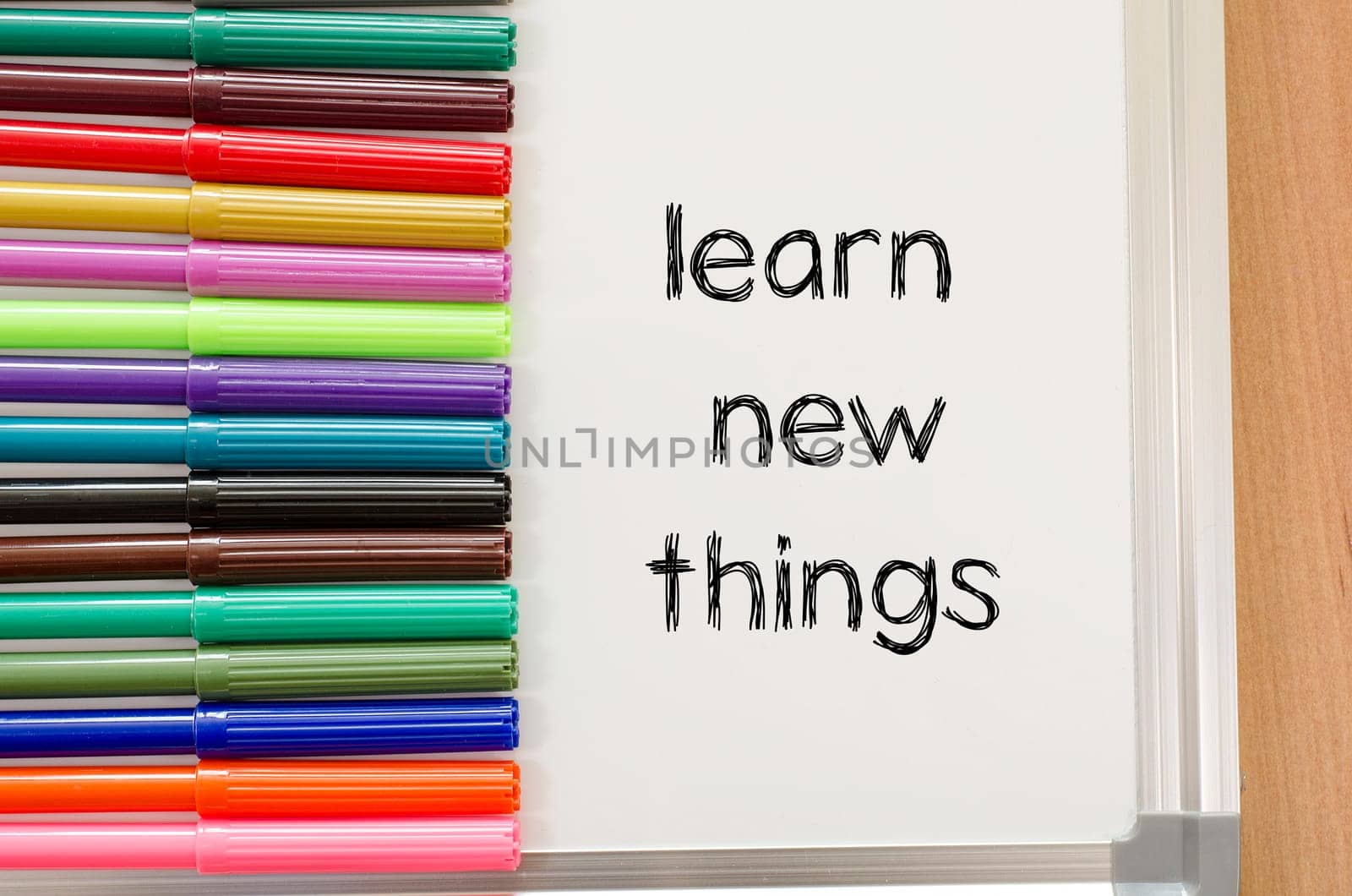 Felt-tip pen and whiteboard on a wooden background and learn new things text concept