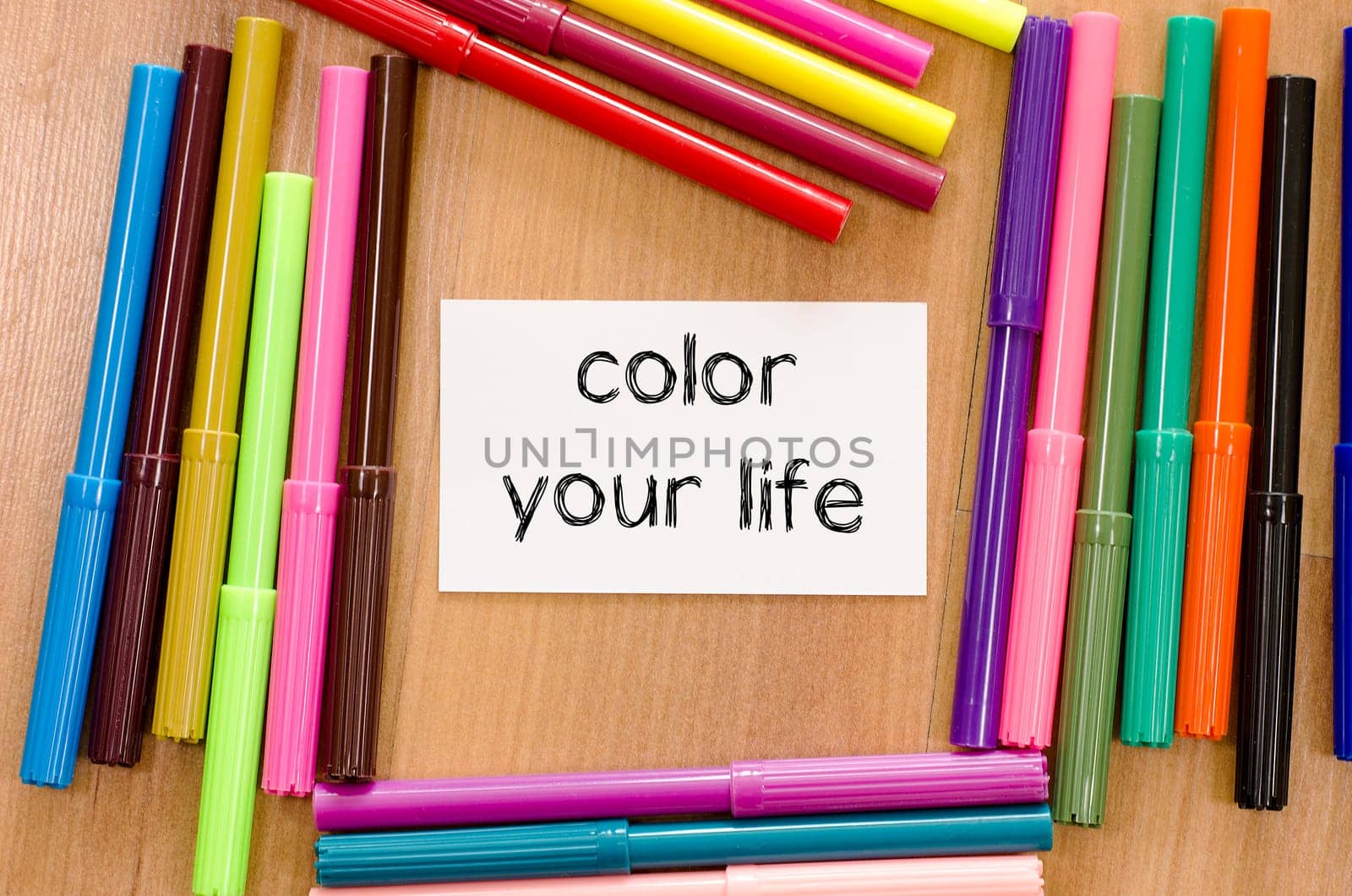 Felt-tip pen and note on a wooden background and color your life text concept