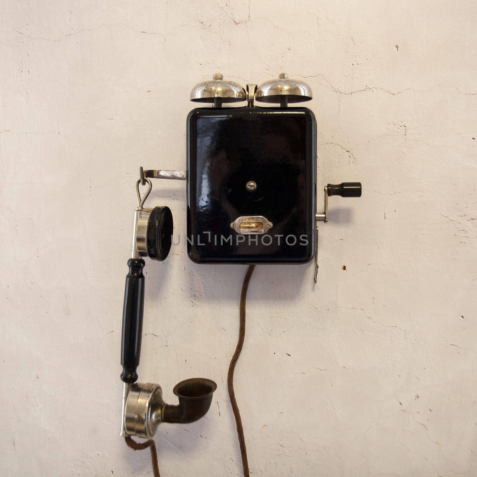 Old dialschool phone by a gray wall