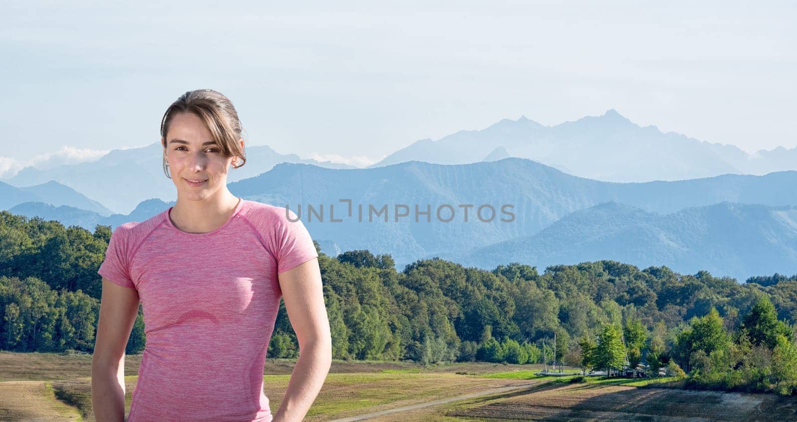 portrait of young sporty woman , mountains in  background