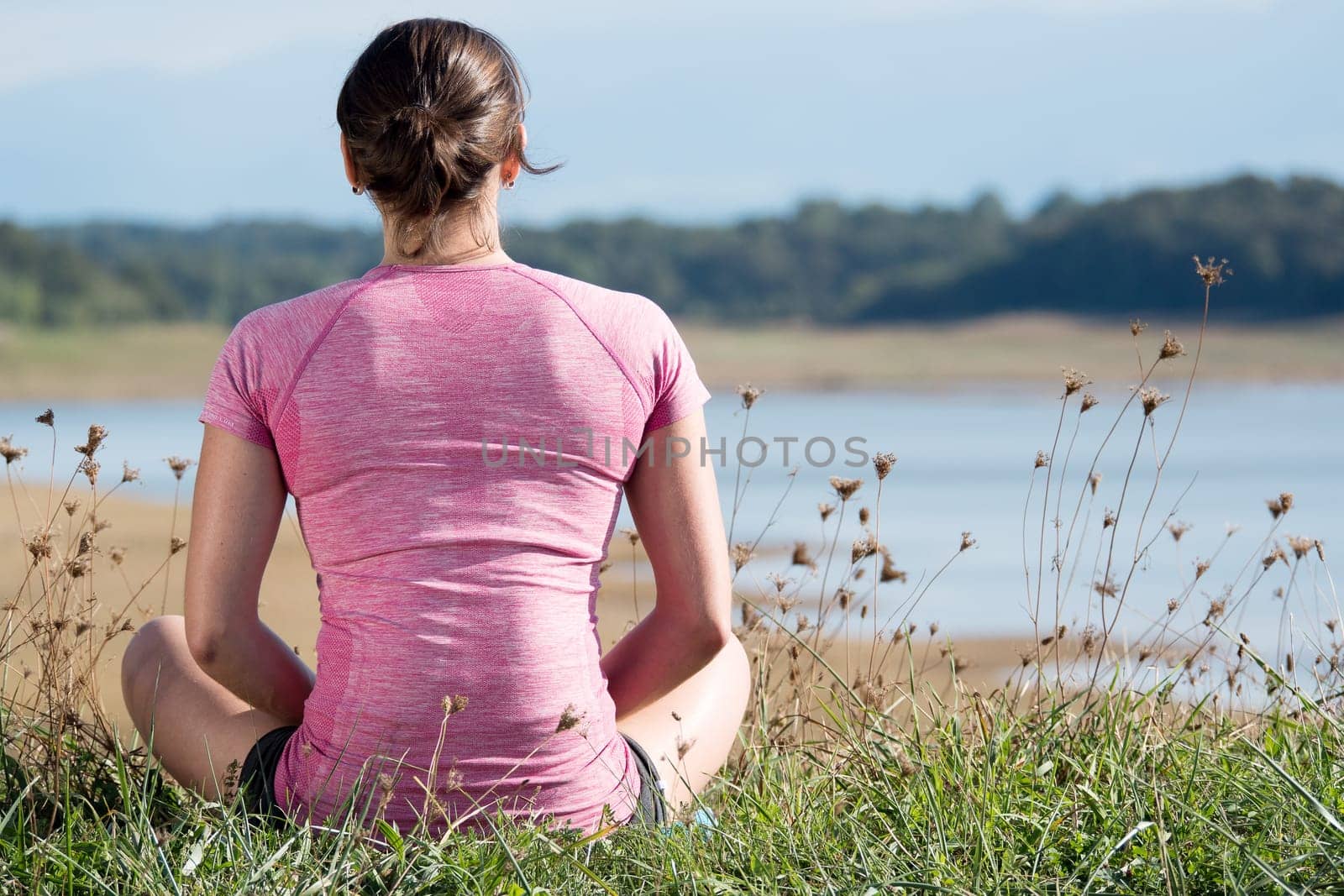 portrait of young sporty woman with pink sportswear, back view