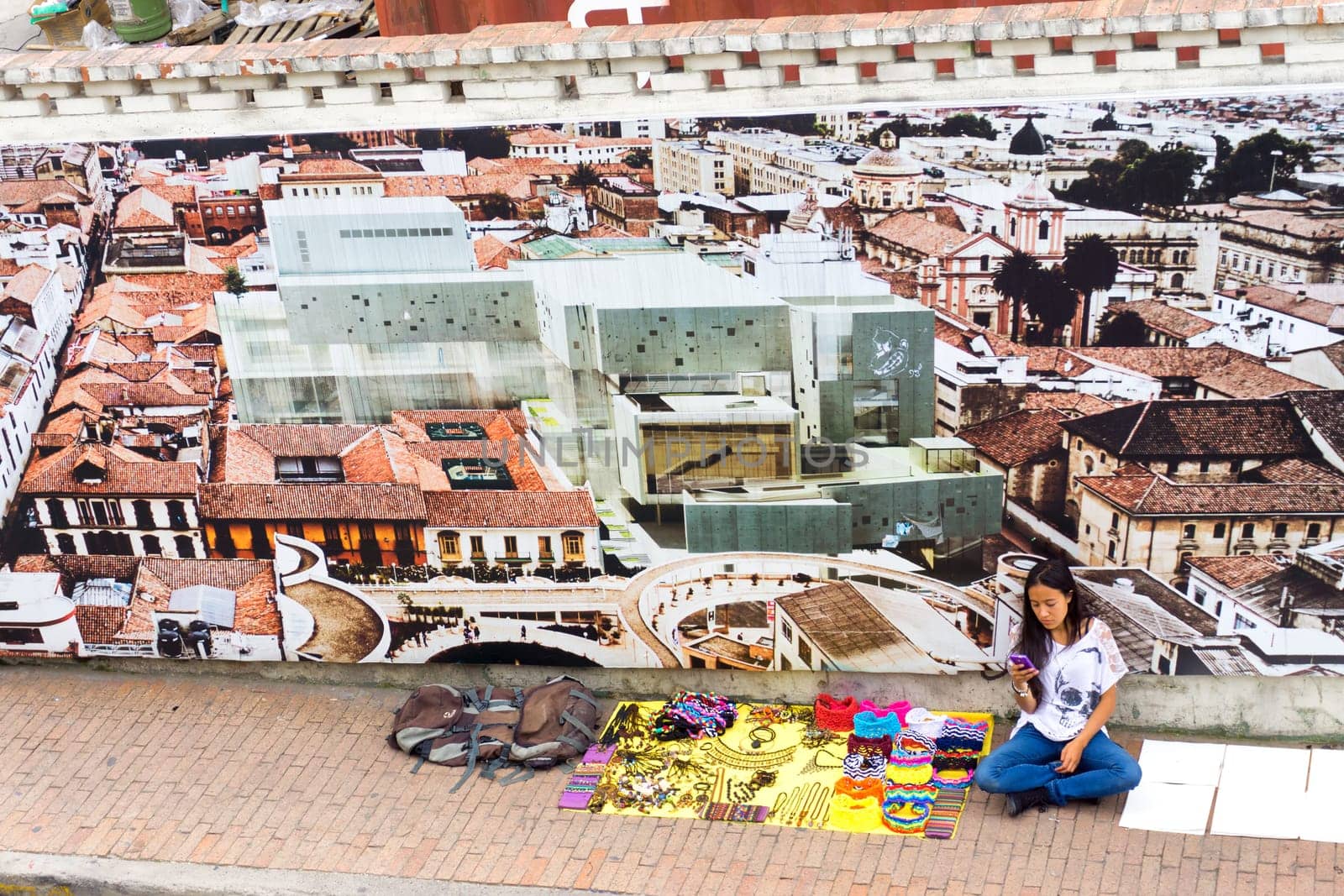 BOGOTA, COLOMBIA - APRIL 21: Street vendor selling souvenirs texts on her phone in Bogota, Colombia on April 21, 2016