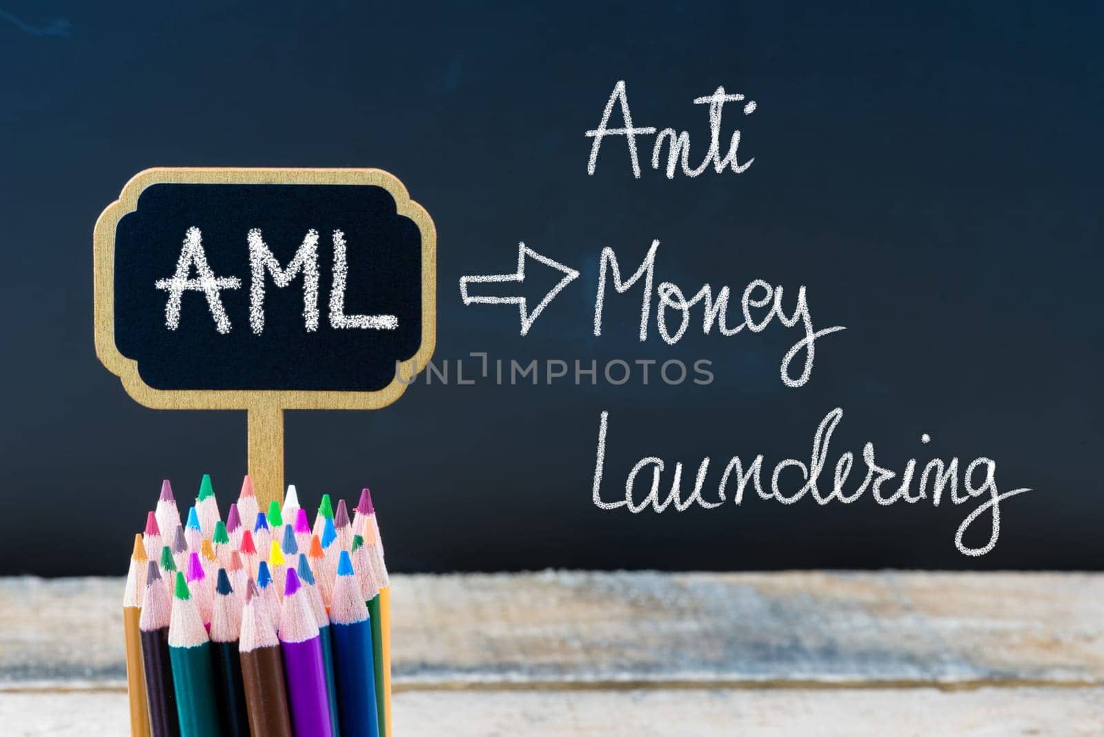 Business Acronym AML Anti Money Laundering written with chalk on wooden mini blackboard labels and chalkboard background.