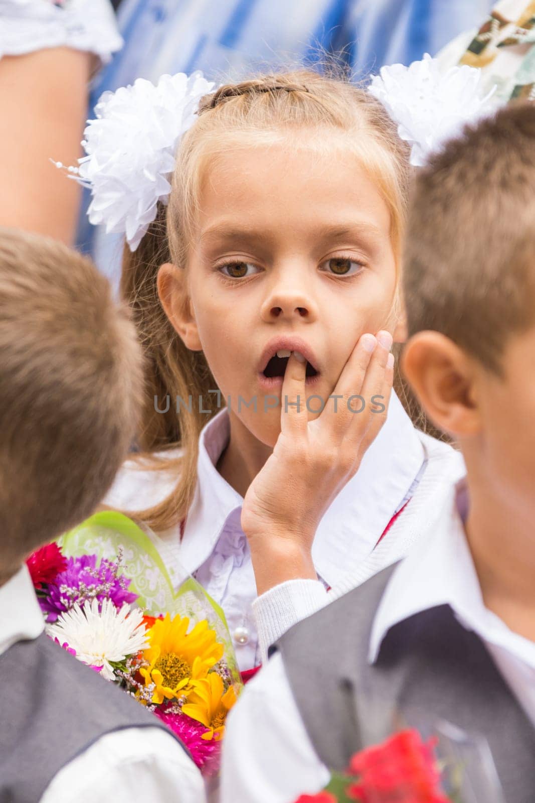First grader on the line of the first of September thinking stuck a finger in his mouth
