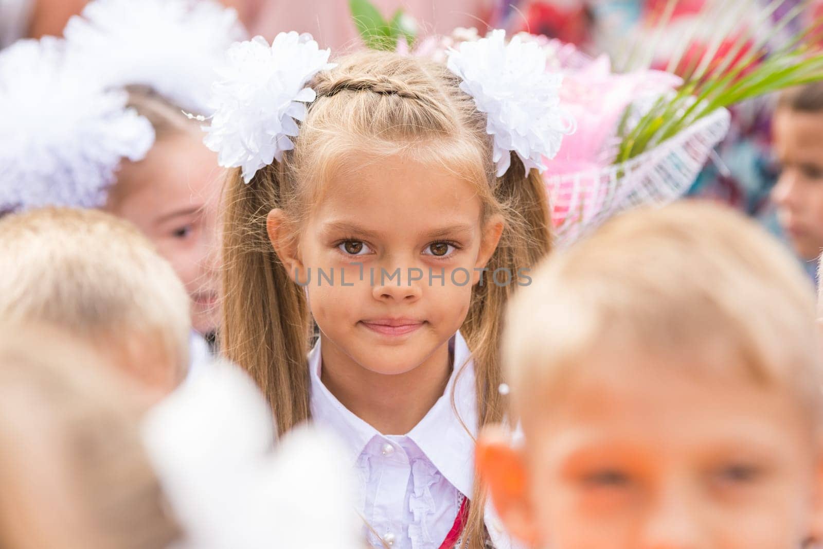 First grader close-up in a crowd of children on line the first of September