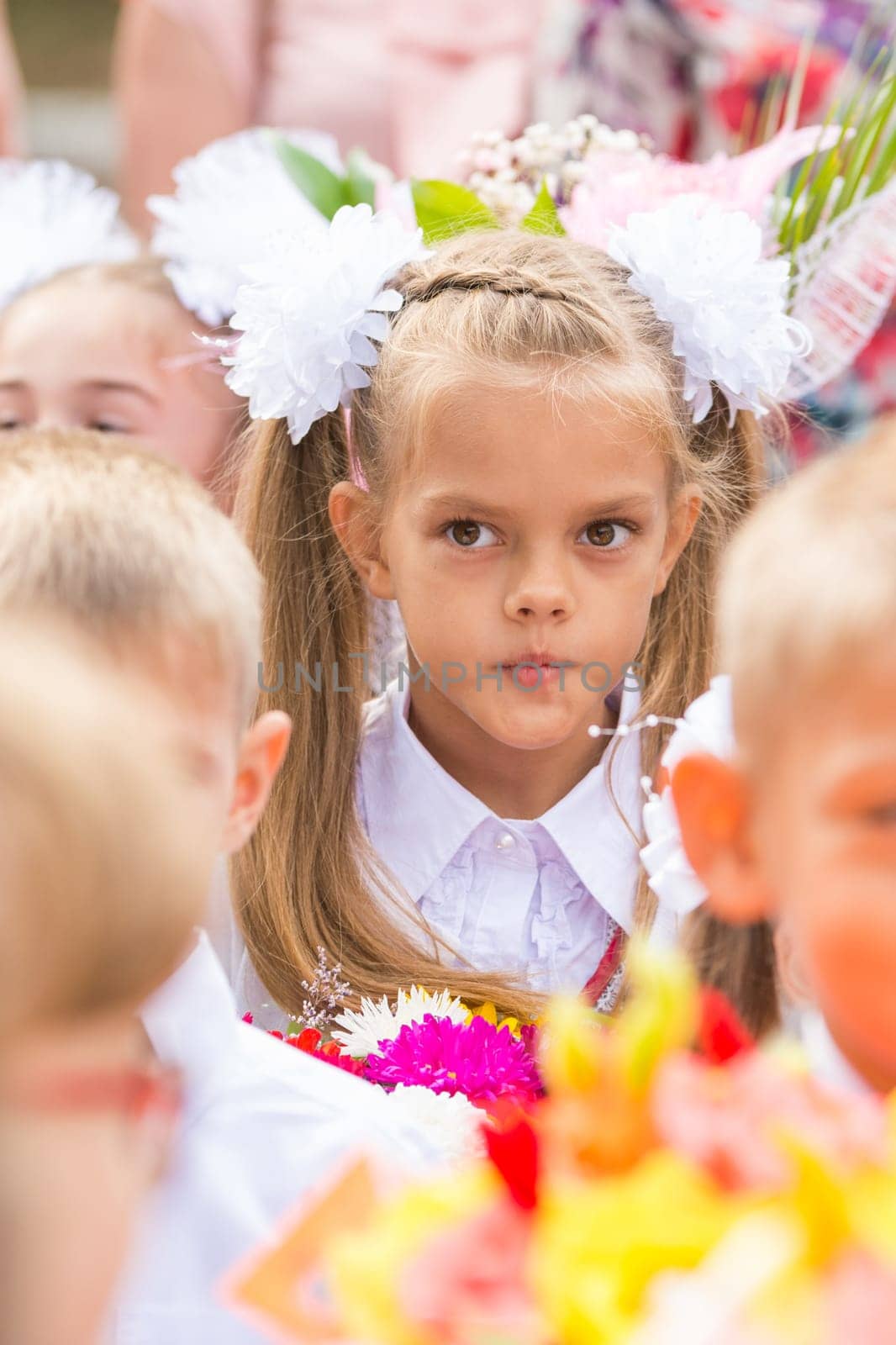 Thoughtful first grader in the crowd of classmates on line the first of September
