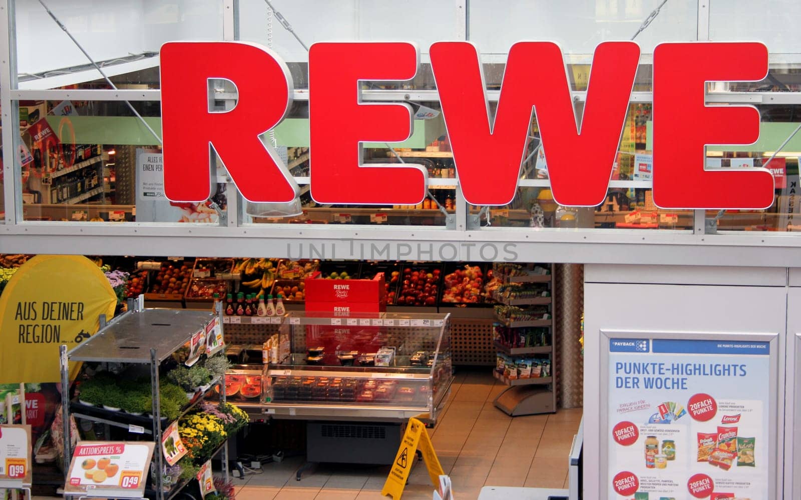 REWE logo at the entrance of a supermarket