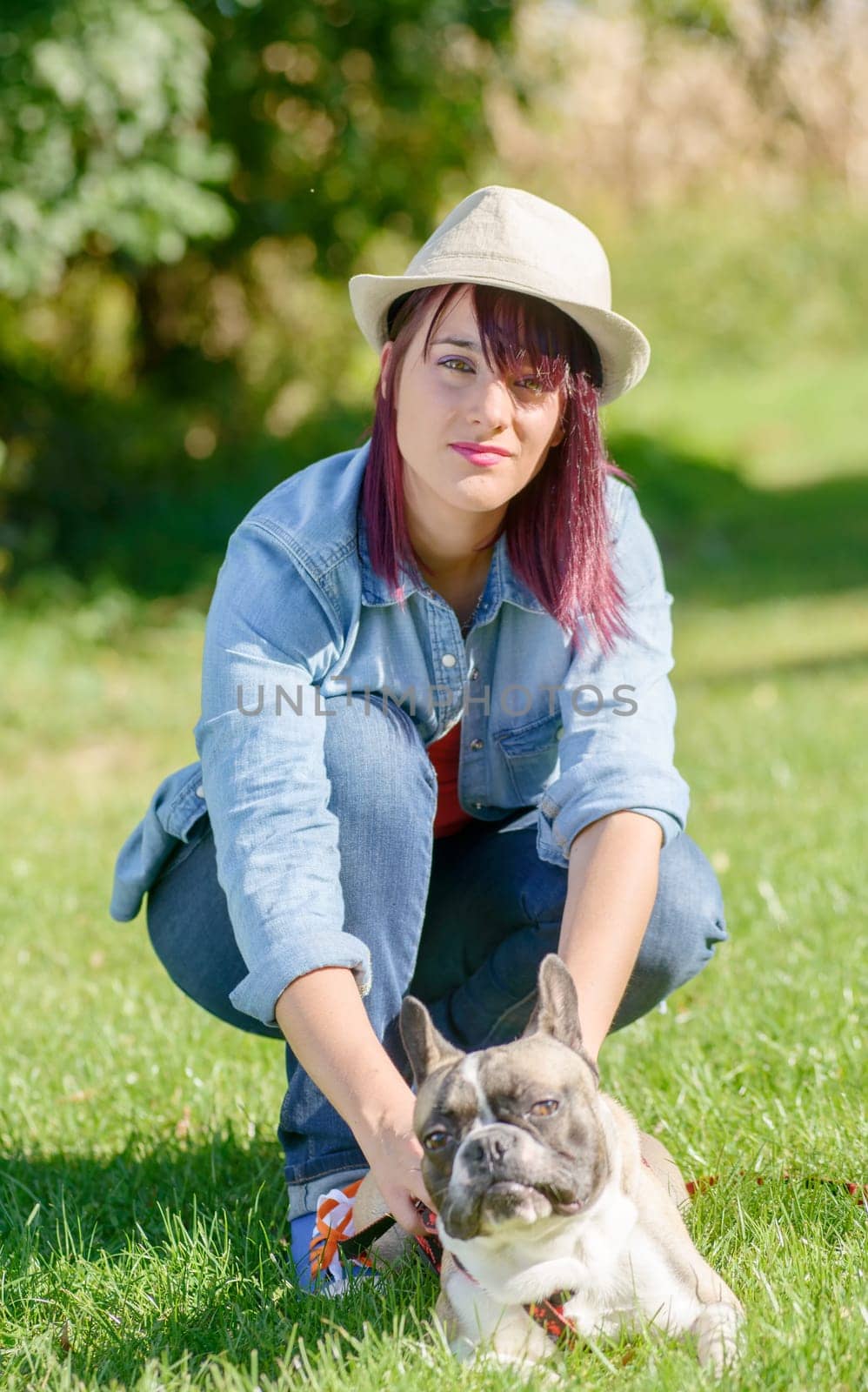 beautiful young woman with her dog french bulldog in the park