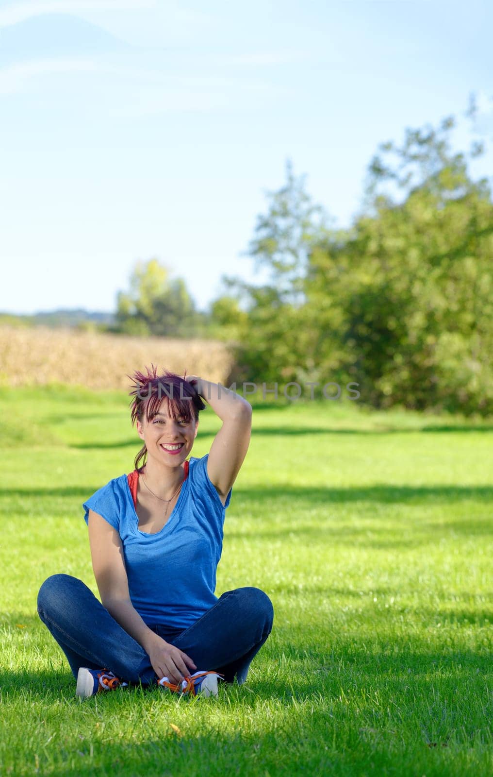 beautiful young woman sitting in the grass in the countryside