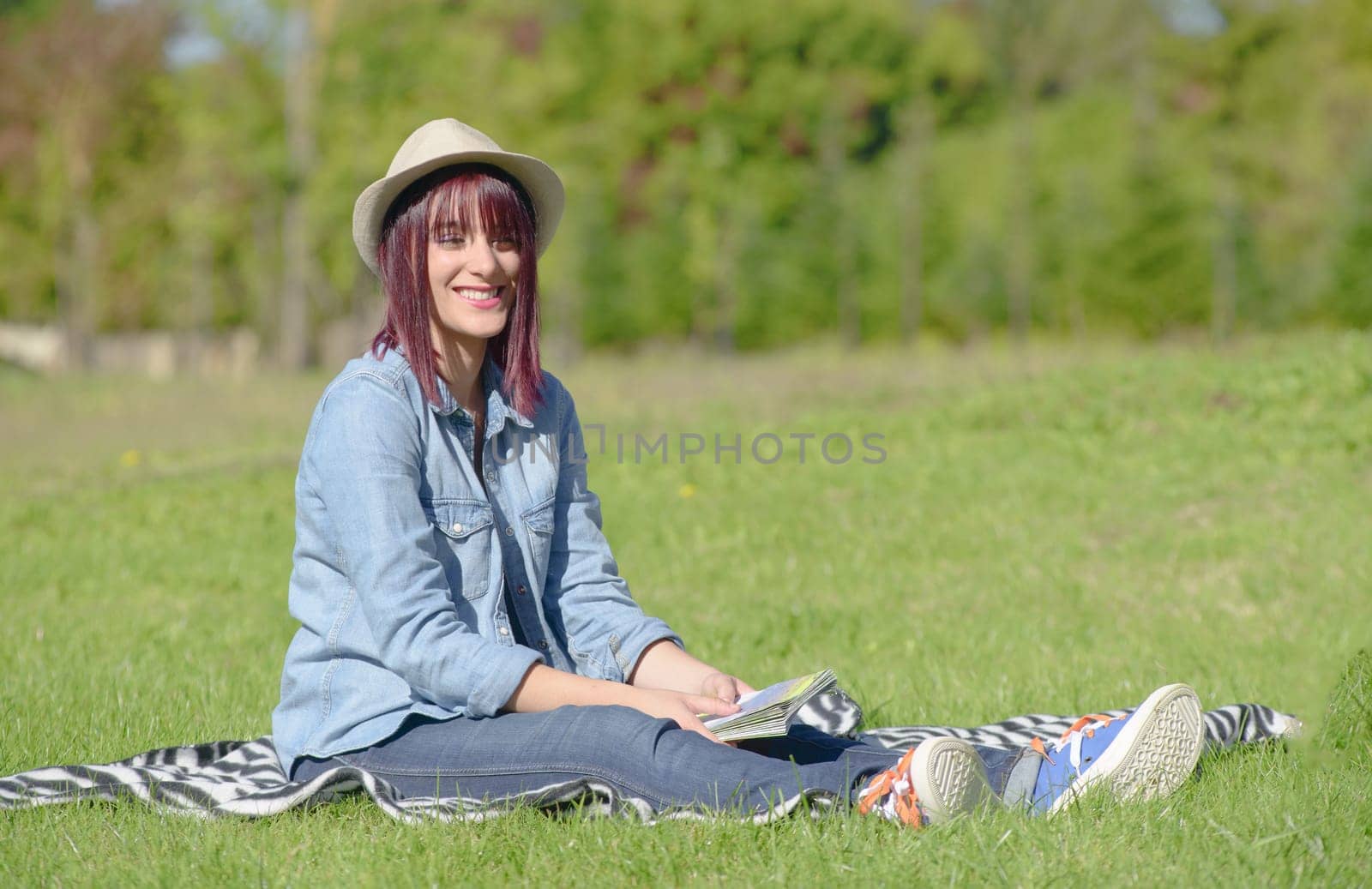 beautiful young woman sitting in the grass in the countryside