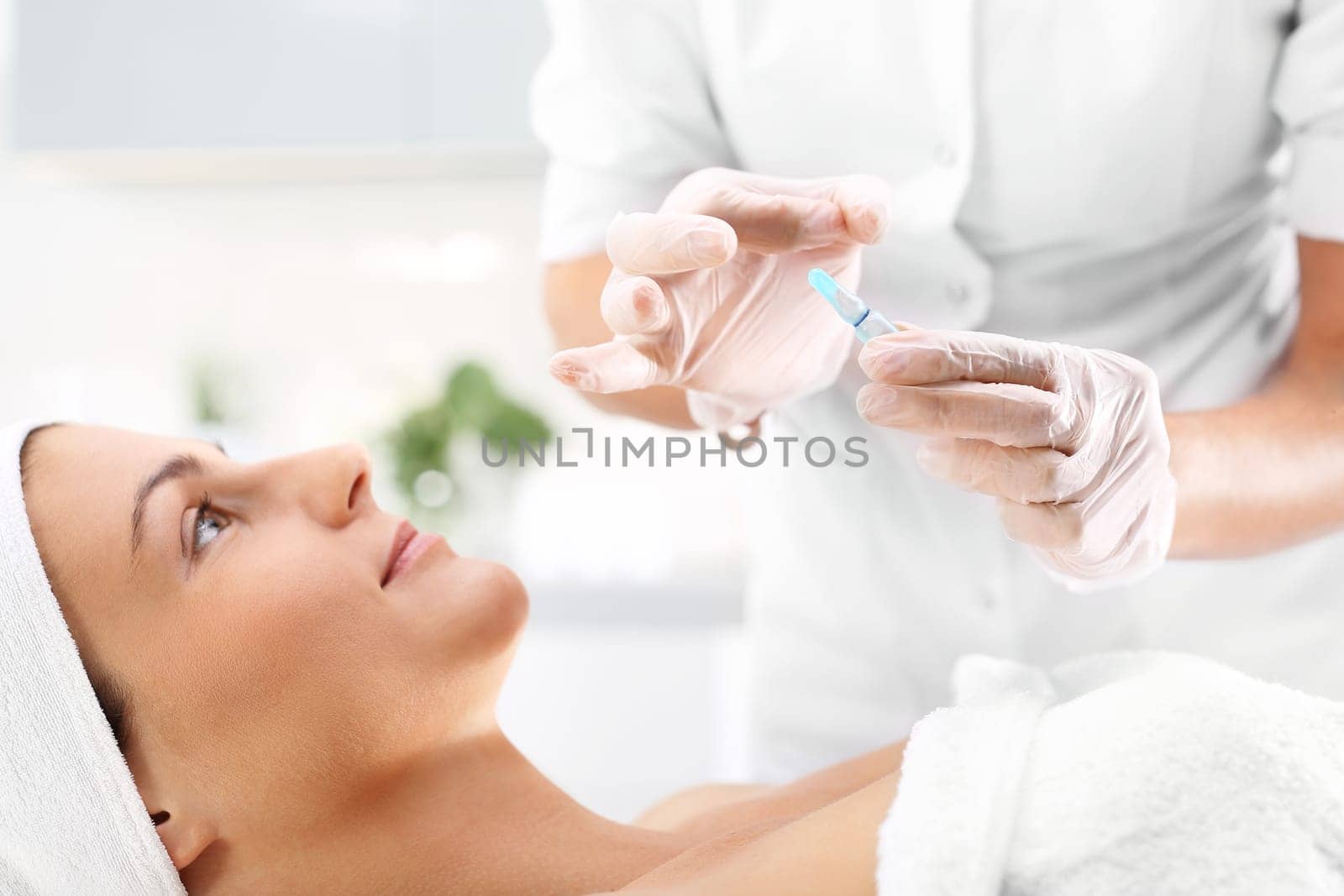 cosmetic ampoule,woman in a beauty salon,vitamin c in a cosmetic ampoule.\n