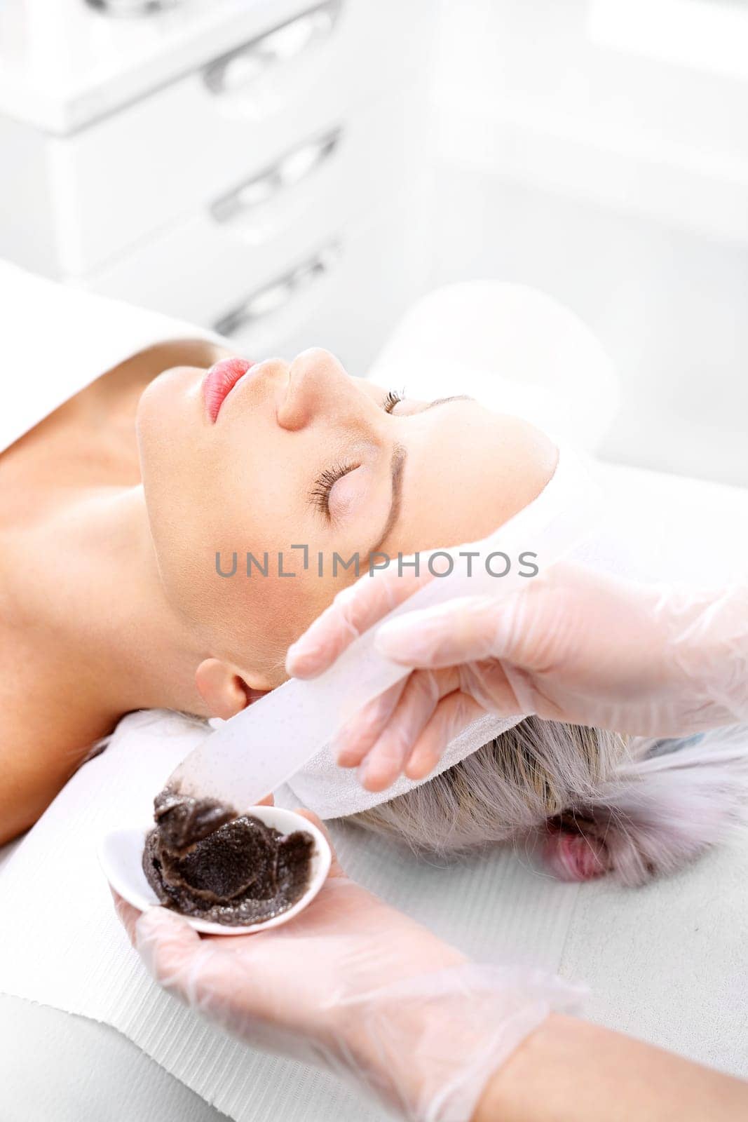 sugar peeling,treatment in a beauty salon.\ncleansing mask,a woman in a beauty salon.\n