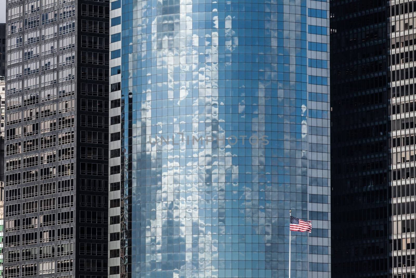 Modern skyscraper background and US flag in Manhattan, New York City.