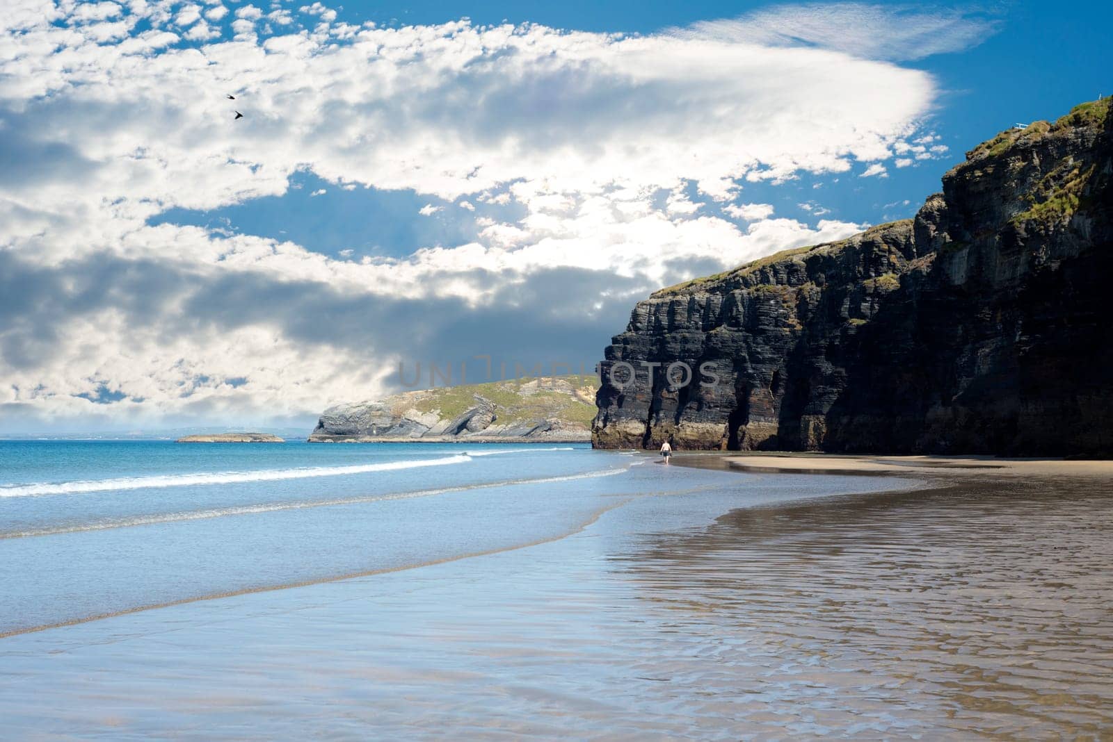 tourists in ballybunion beach and cliffs on the wild atlantic way at low tide