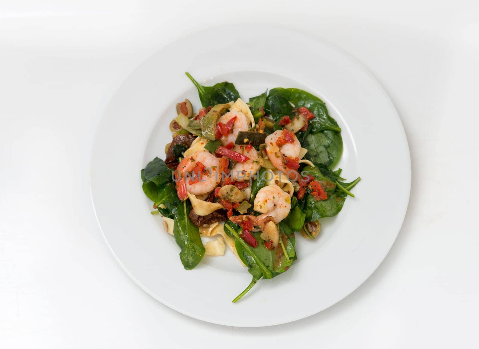 close up on fresh salad of prawns,pasta,baby spinach and chili,top view