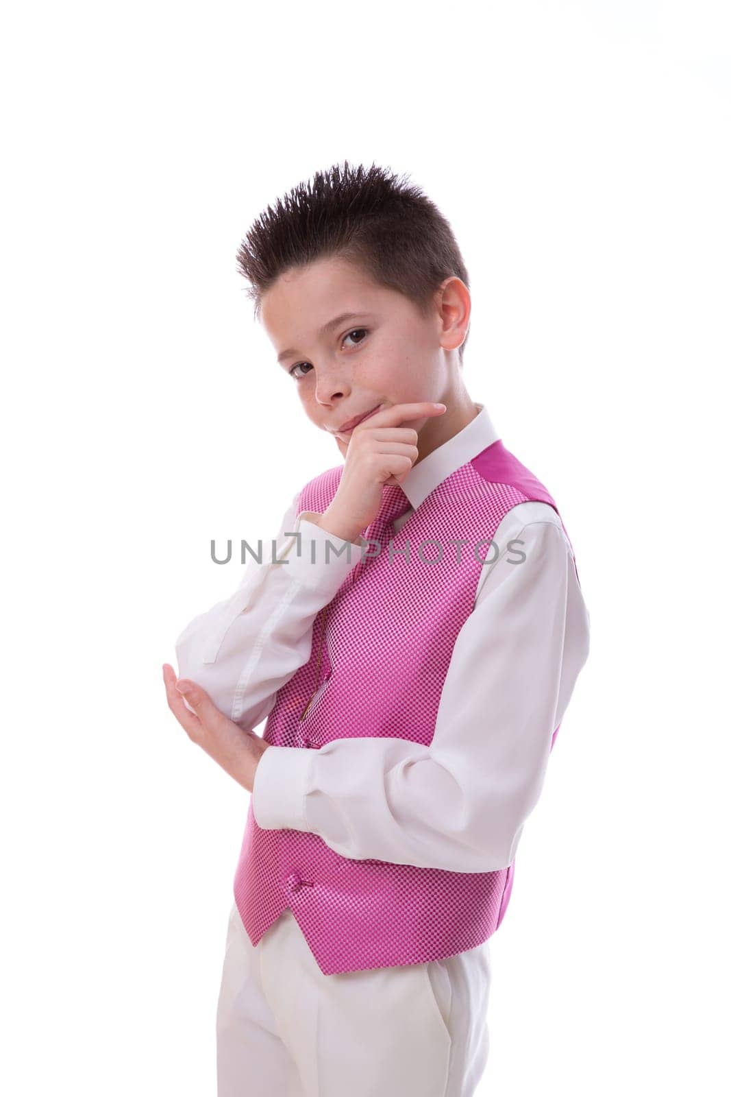 Young boy holding his chin and looking at camera celebrating his First Holy Communion on a white background