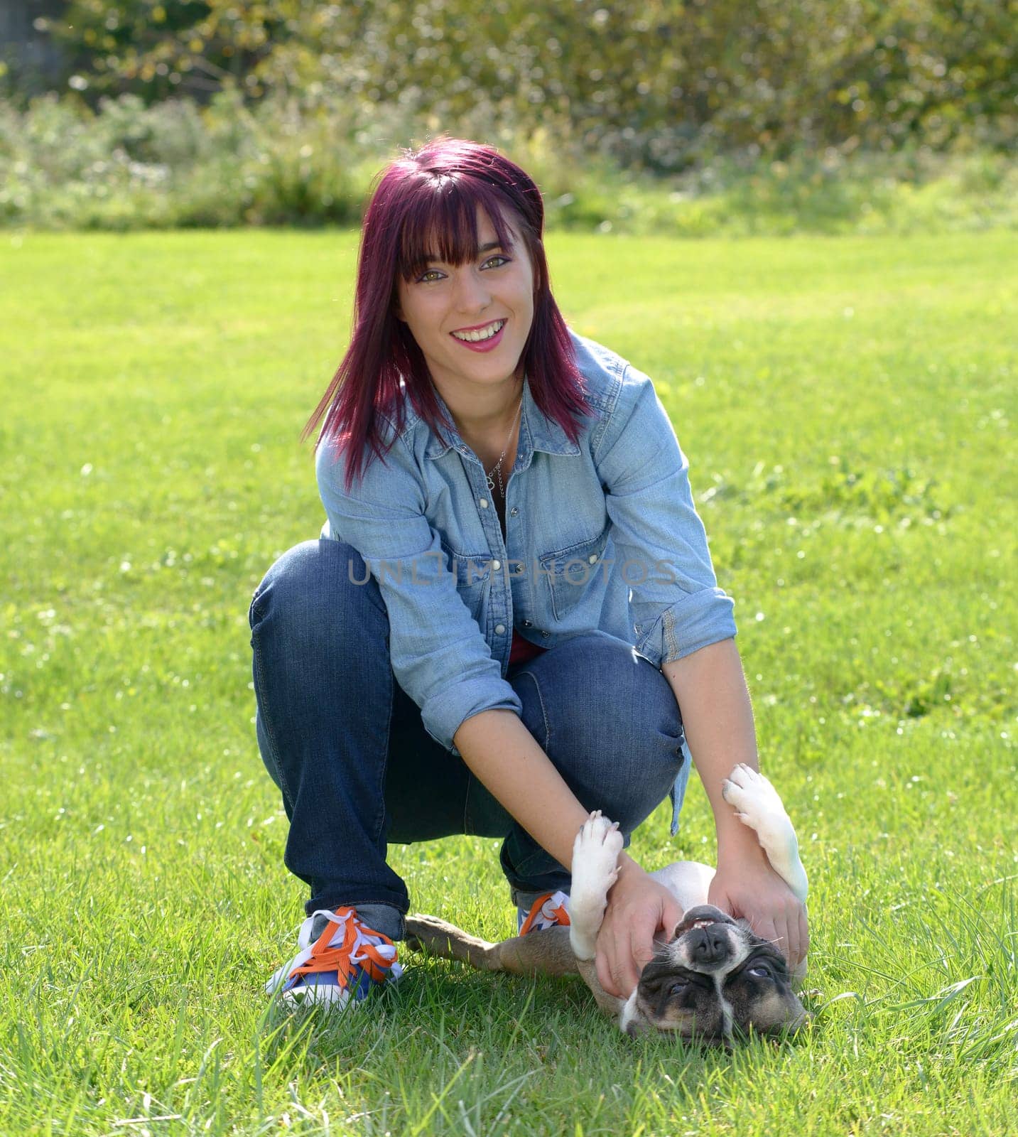 beautiful young woman with her dog french bulldog in the park