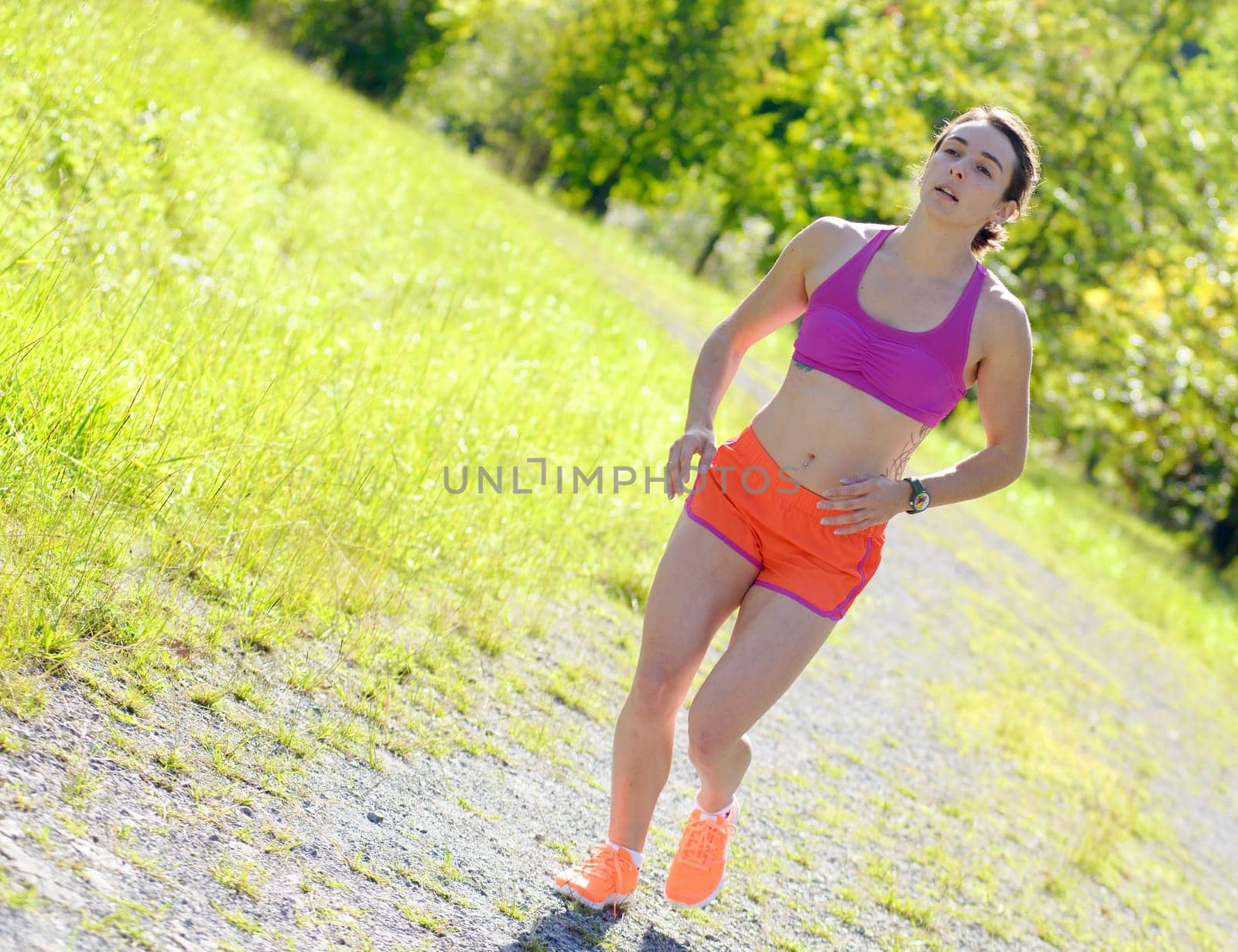Beautiful  young athletic woman running in countryside