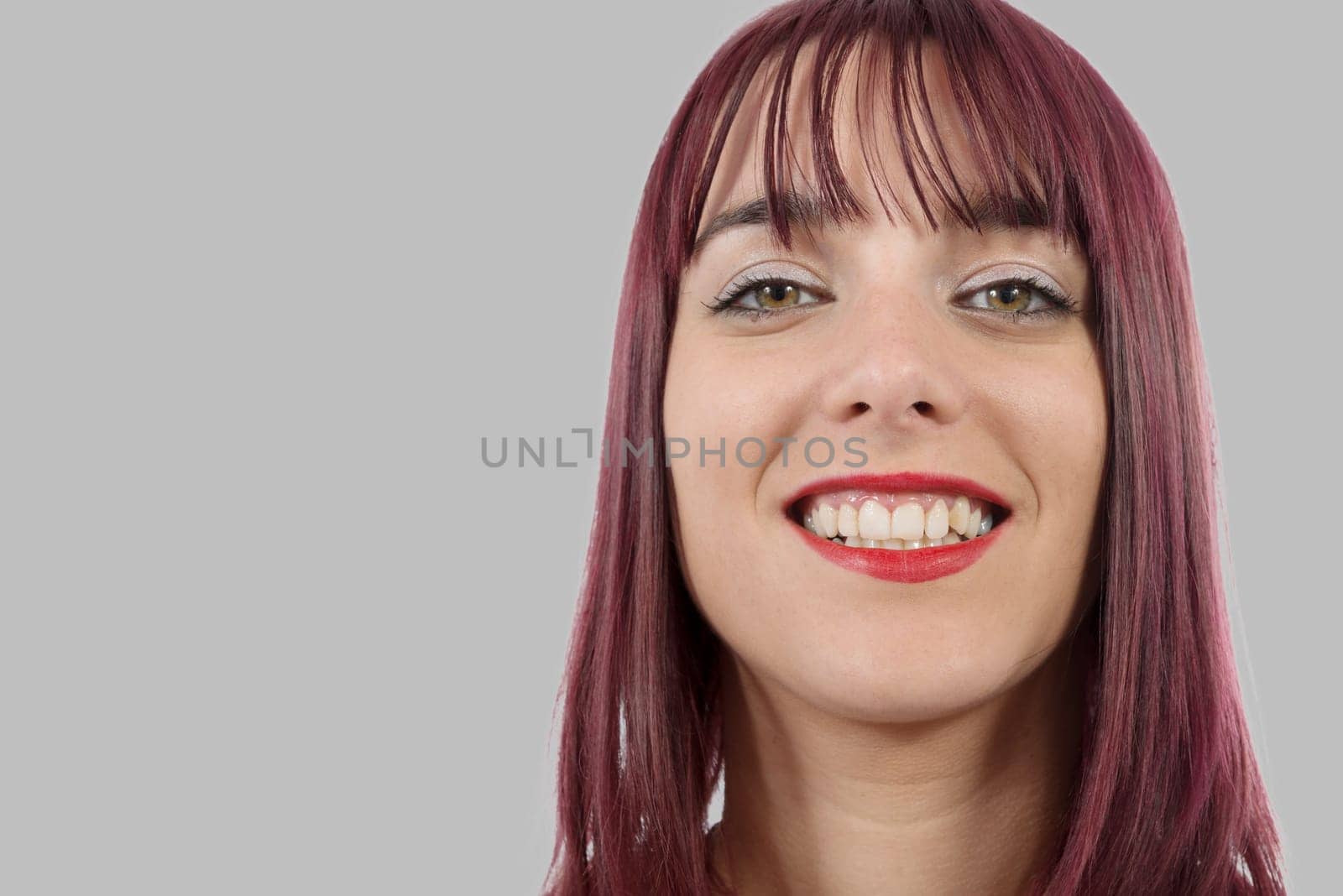 portrait of a beautiful young woman with green eyes on grey background