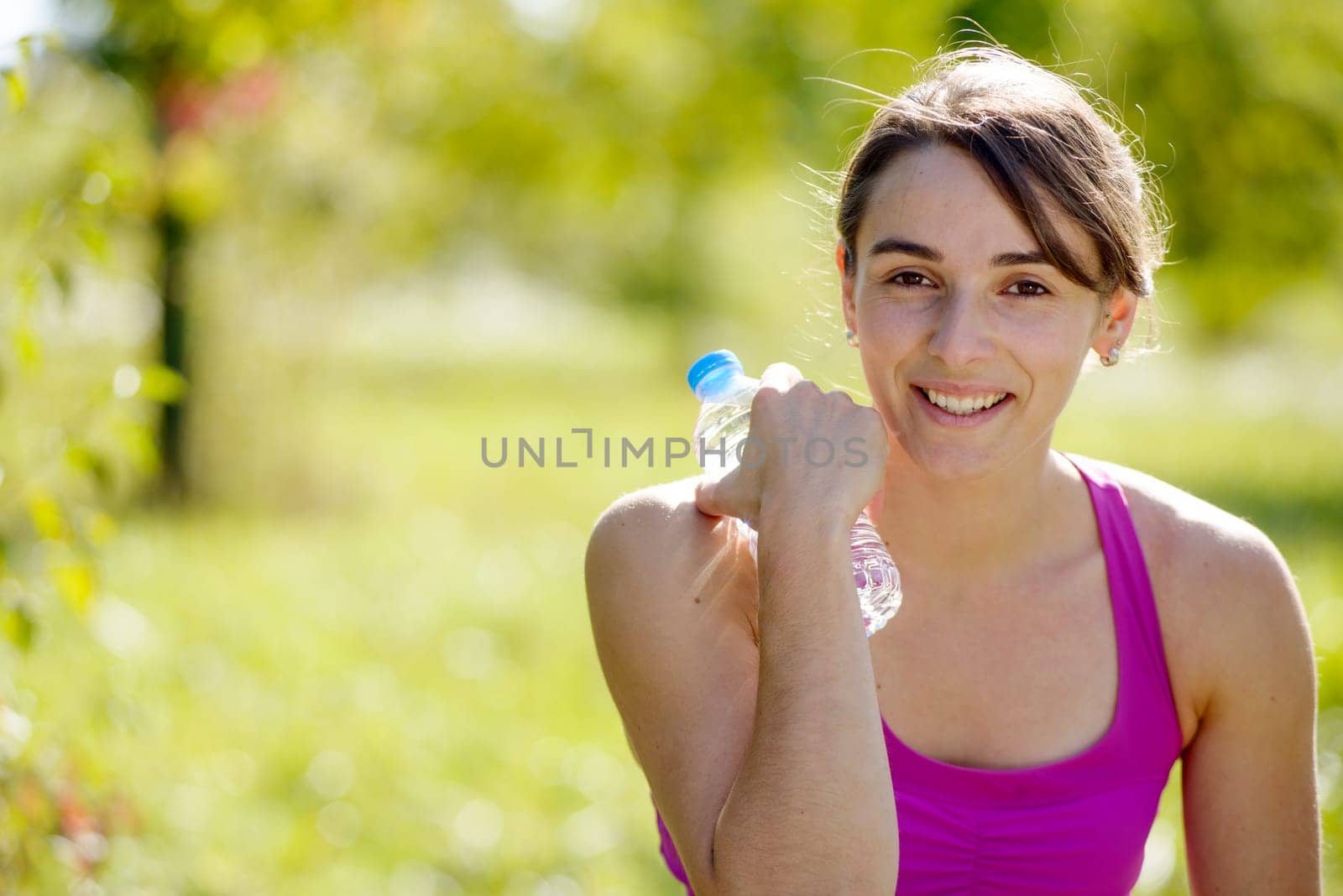 beautiful athletic girl drinking water after exercising