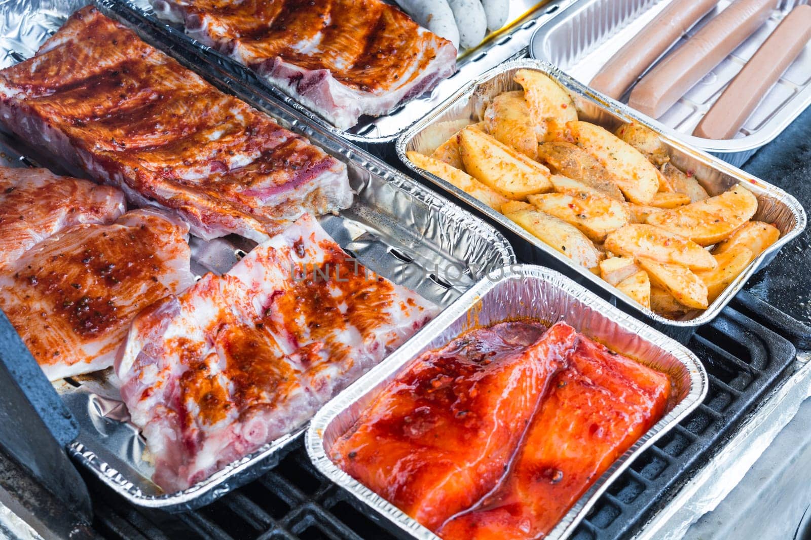 Various delicious grilled meat and sausage on a grill..