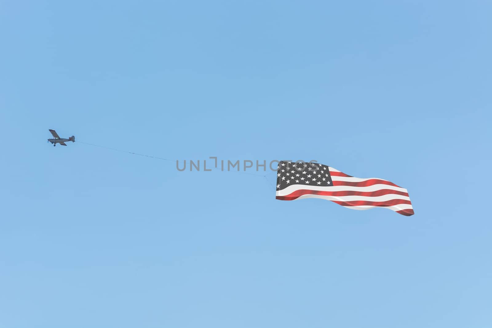 Banner tow,small powered aircraft with tow banner for advertising.. Here is the flag of America...