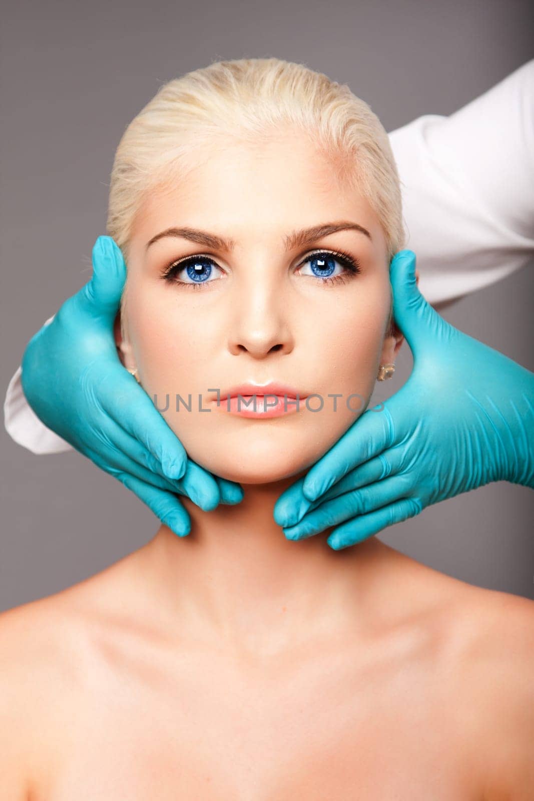 Beautiful face of young woman for Aesthetics facial skincare concept touched by cosmetic plastic surgeon beautician.