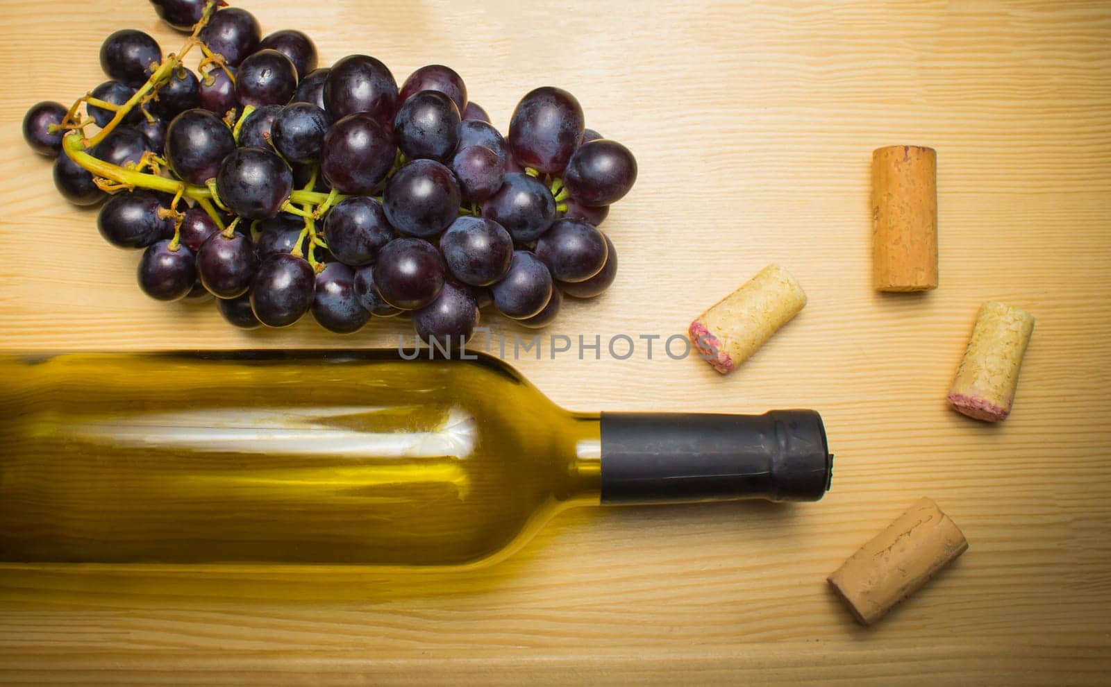 The empty bottle of wine with corkscrews and glass of coconut on wooden background