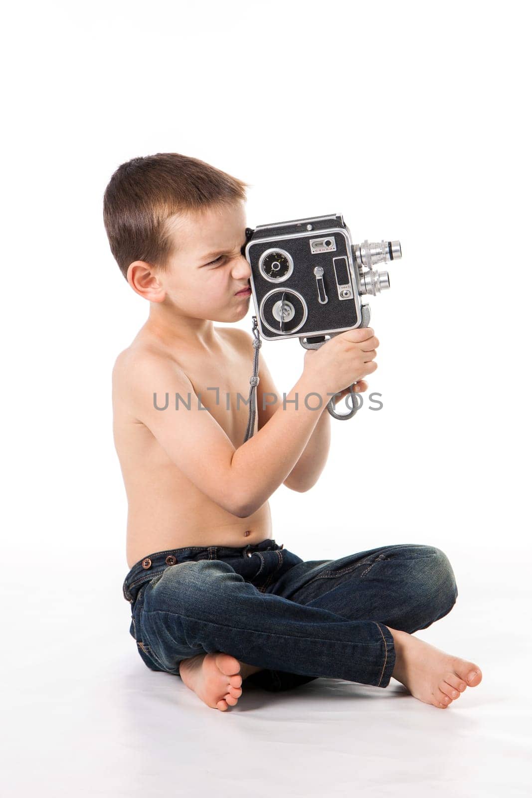 Caucasian boy plays to shoot at the old camera.