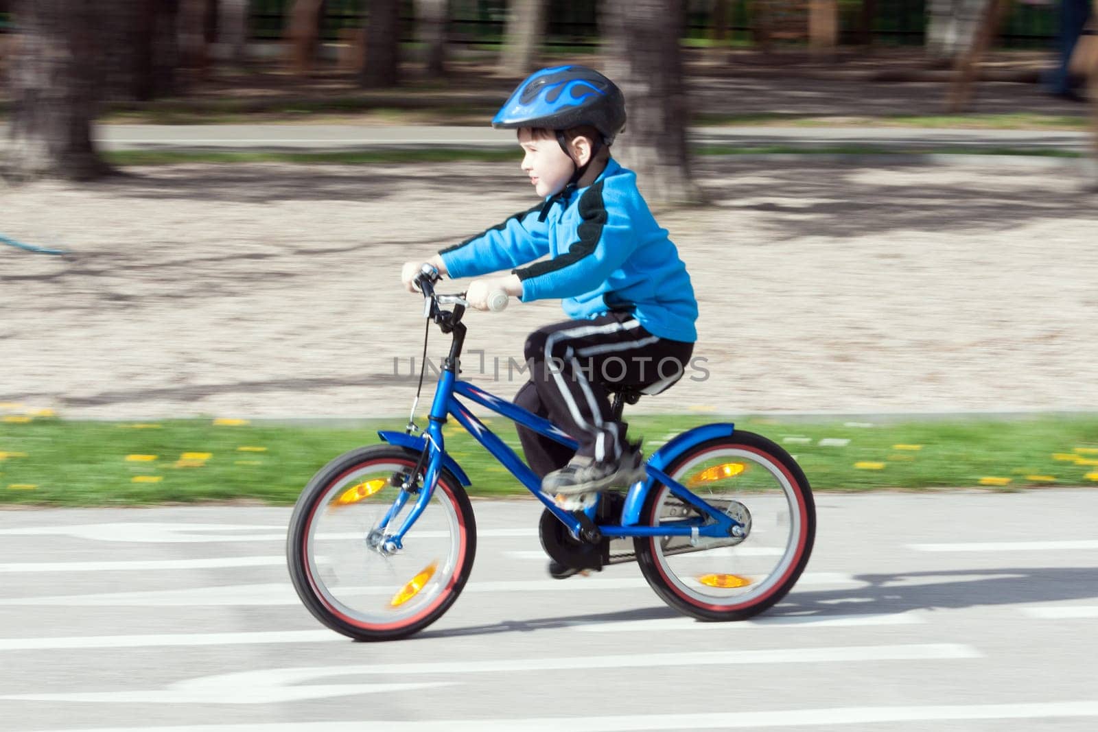 child on a bicycle at asphalt road on traffic playground - blurred panning method