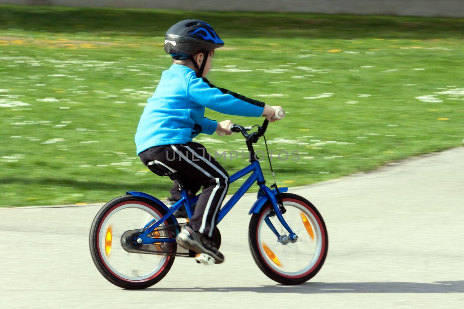 child on a bicycle at asphalt road on traffic playground - blurred panning method