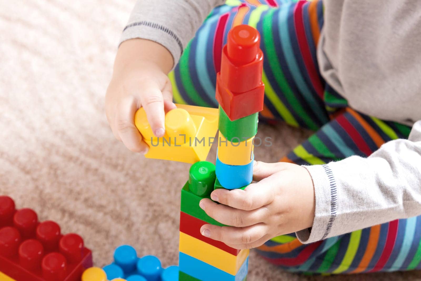 Playing little boy with colored cubes
