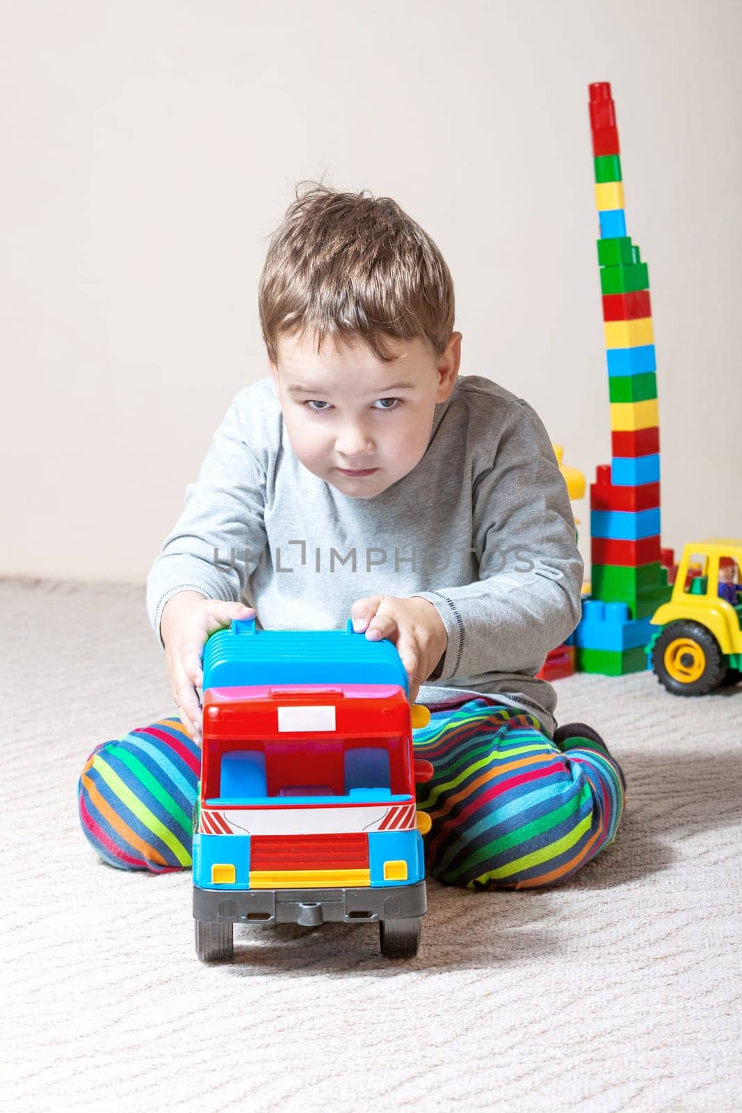 Playing little boy with colored cubes