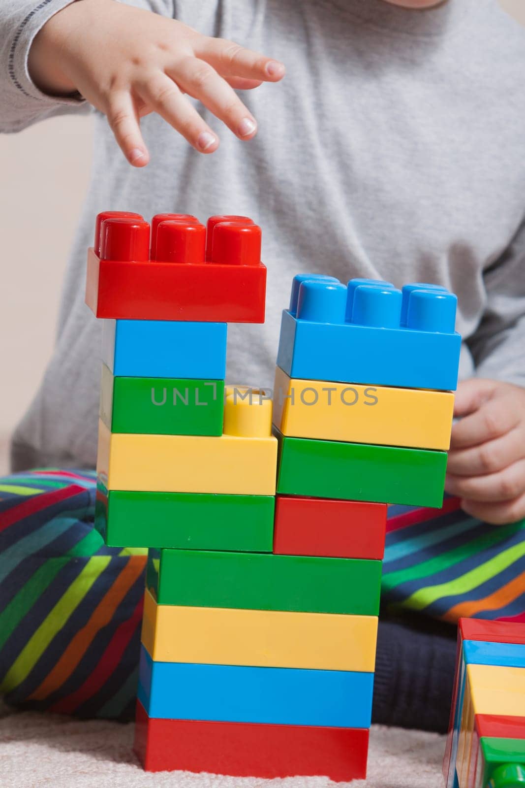 Playing little boy with colored cubes