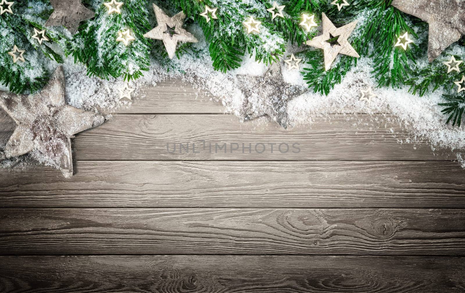Christmas background in natural,elegant and simple wood style,with a border of fir branches,wooden stars and snow