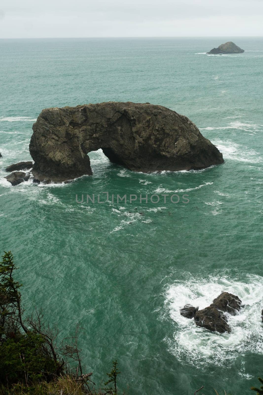 Surf crashes up against Arch Rock off the Oregon Coast