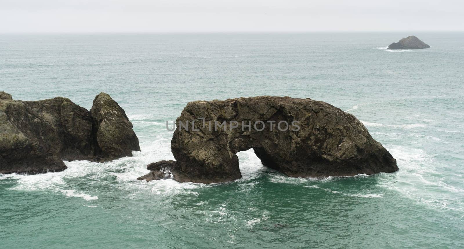 Surf crashes up against Arch Rock off the Oregon Coast