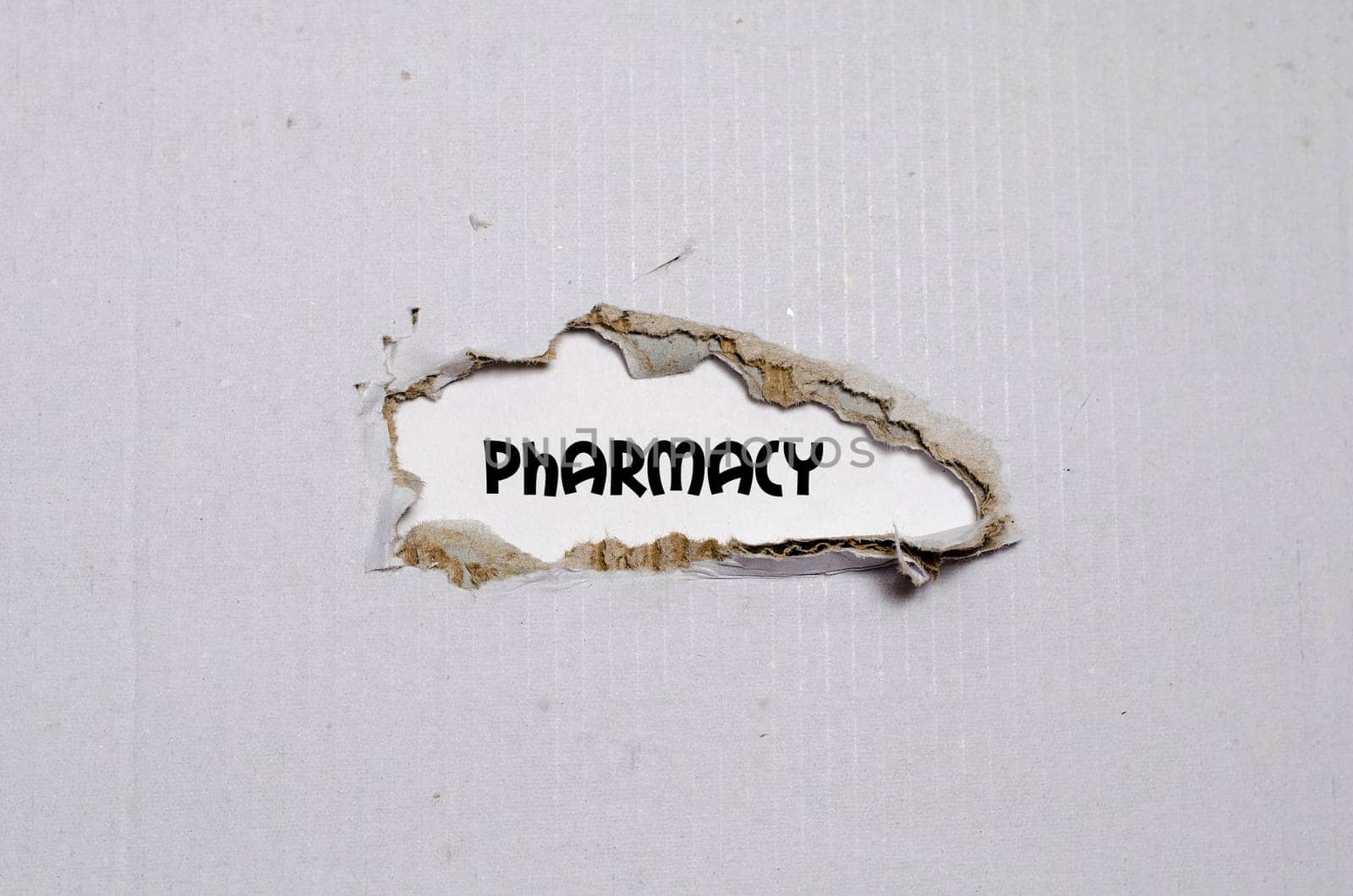 The word pharmacy appearing behind torn paper