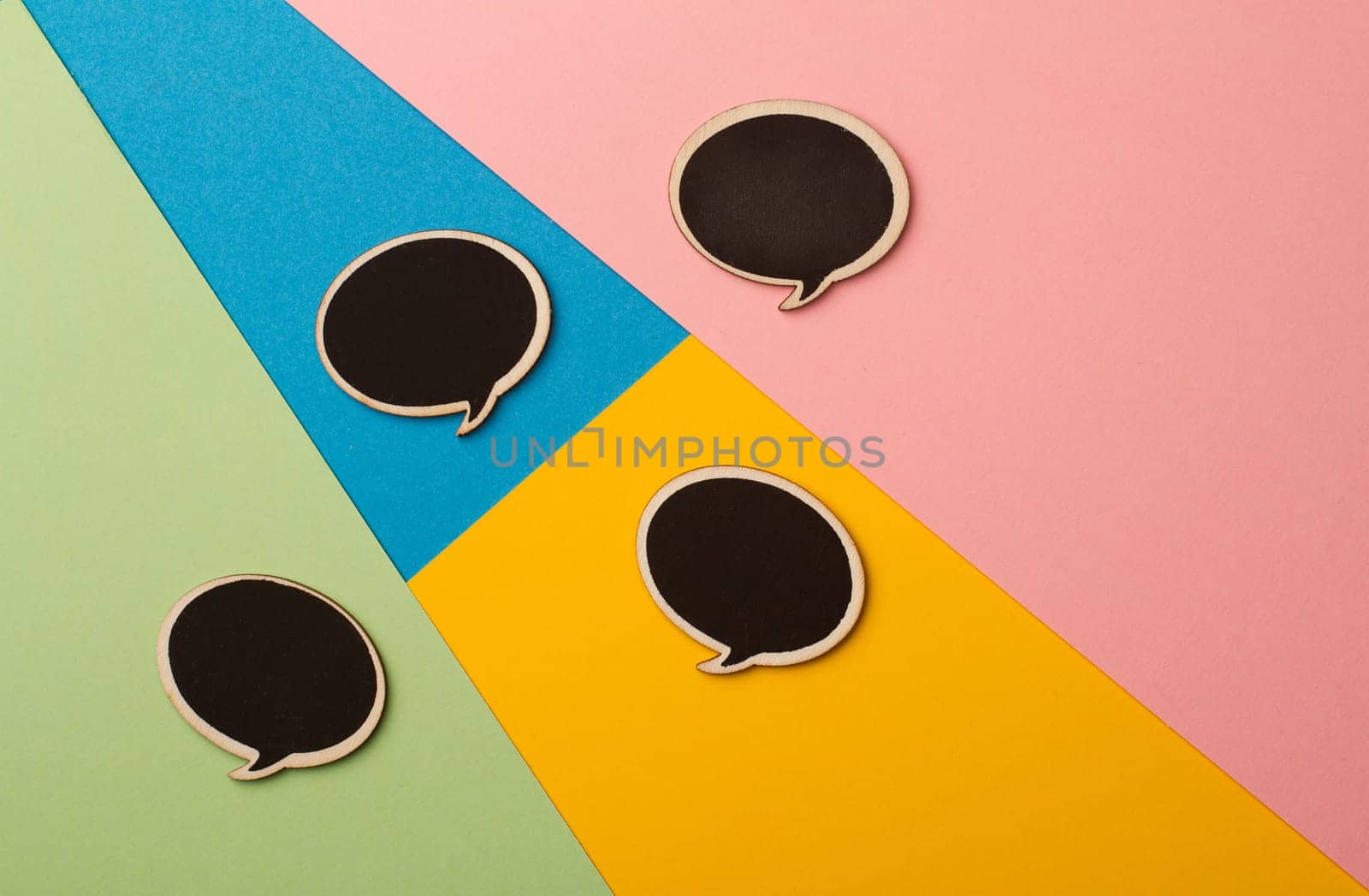 Top view of round chalk board speech bubbles on colored papers, metaphor, concept for communication